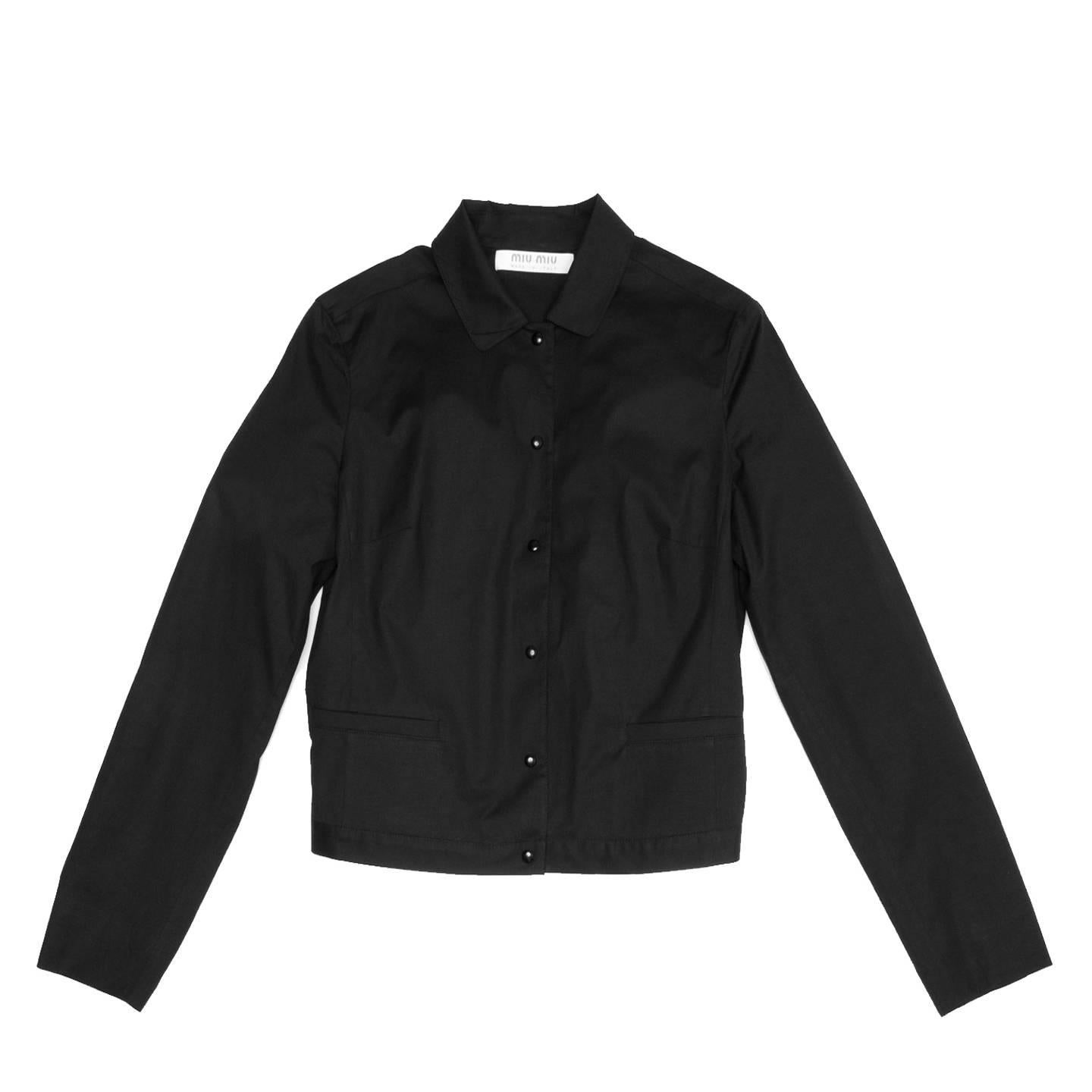 Miu Miu black stretch cotton hip length shirt jacket with tight fit and peter pan collar. Center front and cuffs fasten with black metal snap buttons and two small slit pockets sit at waist. Made in Italy.

Size  44 Italian sizing

Condition 