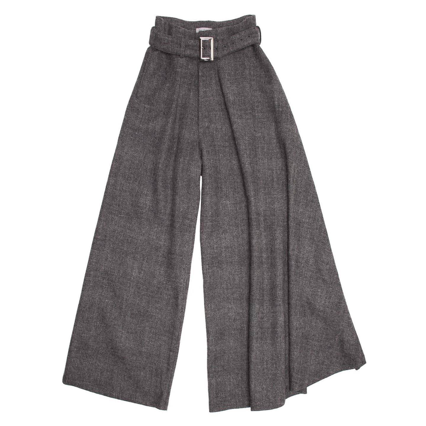 Yohji Yamamoto grey heathered wool palazzo pants with self buckled belt. Slit pockets at front side. Width of wearer's left leg is wider and drapes over front. High waisted with 2 pleats at front and a fly zipper opening.

Size  3 

Condition 
