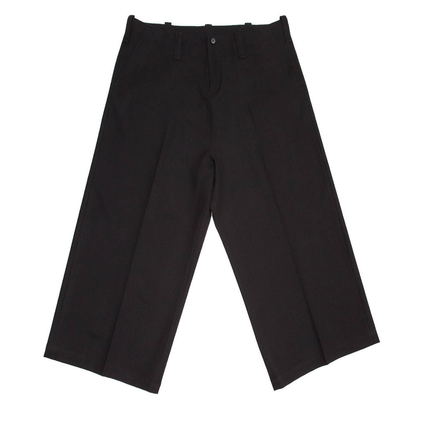Yohji Yamamoto black wool cropped pants with very wide legs. They are a suit pleated style with slash pockets at front starting at top edge of waist, which does not have a band but only a stitching line and wide belt loops.

Size  4 

Condition 