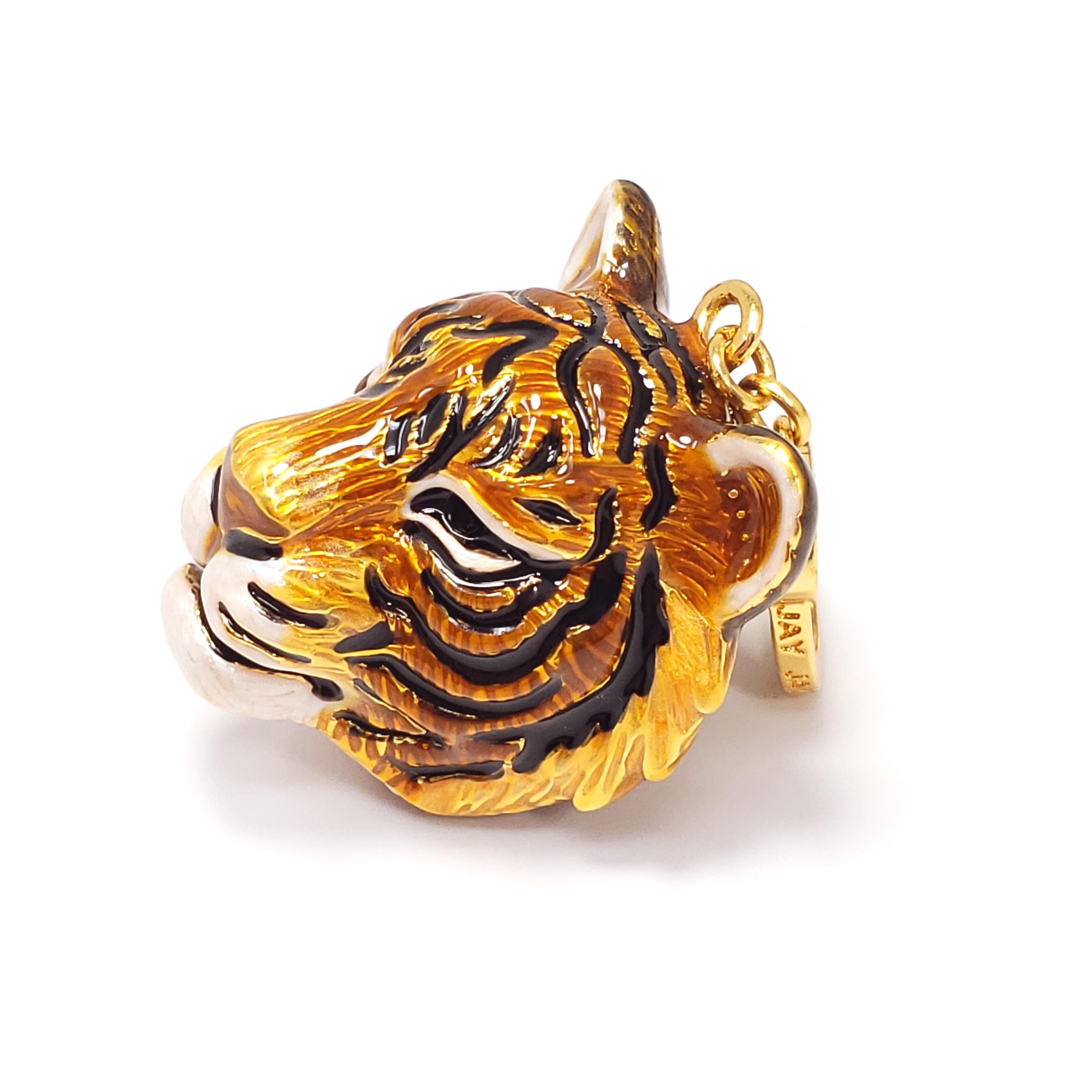 Hand-painted tiger head charm by Jay Strongwater. Shades of yellow, orange, and brown enamel, accented with black and white detailing. This charm can be worn on a bracelet, as a necklace pendant, or even on a keychain. Excellent