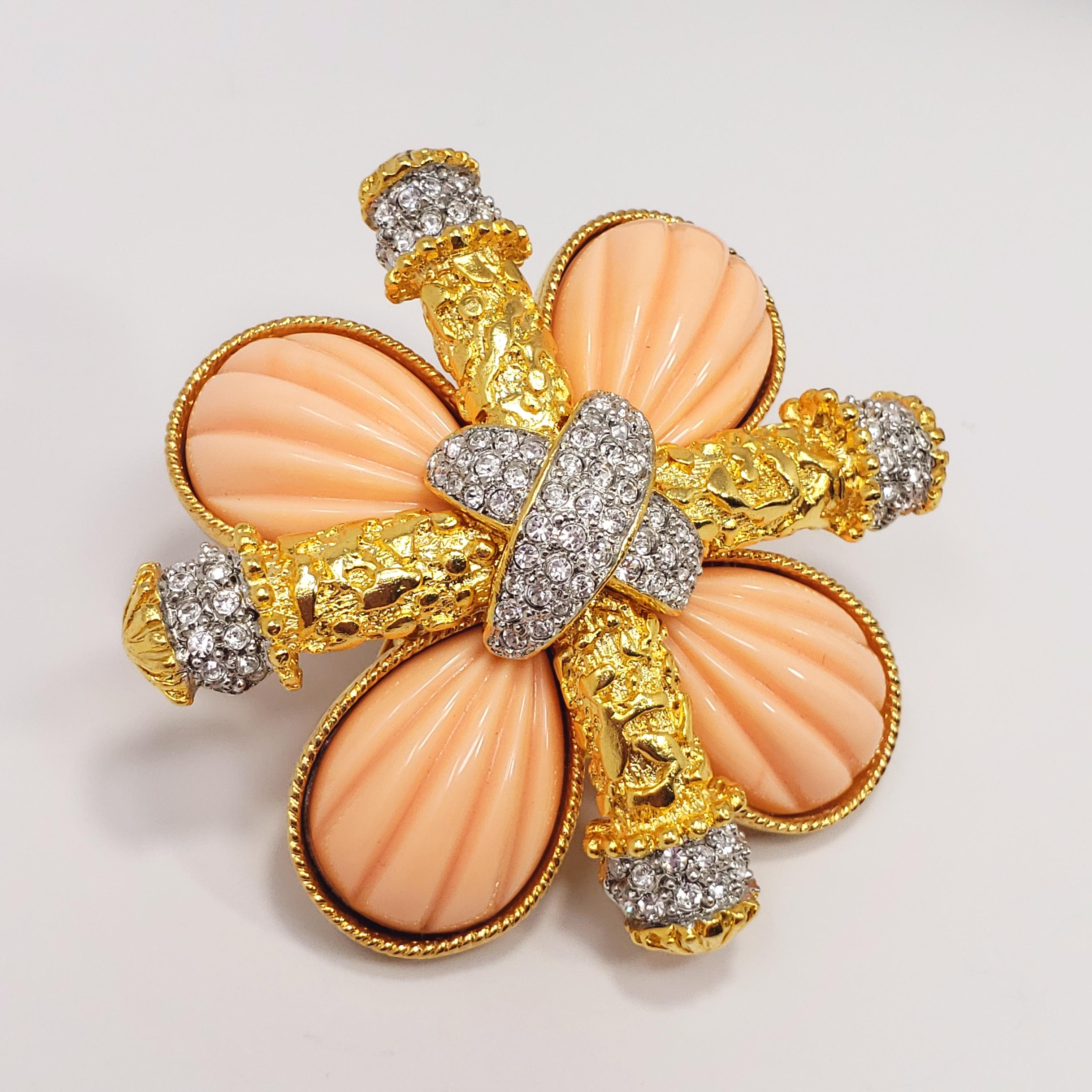 Kenneth Jay Lane maltese-cross style pin/brooch. Carved & polished coral-colored accents, decorated with clear crystals, and set in a gold 22K gold plated, textured, metal setting. The two cross motifs are riveted together into a single stylized