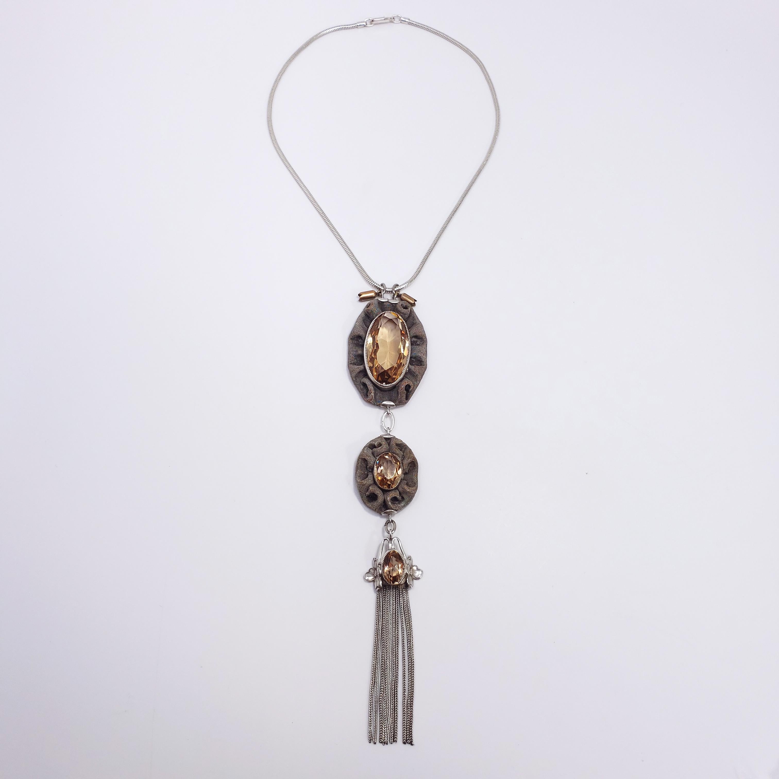 Una collana di epoca vittoriana fatta a mano. Tre ciondoli a goccia pendono in sequenza su una catena a serpente. Ognuno di essi presenta un cristallo allungato, aperto sul retro, di colore champagne/topazio incastonato in un castone a dente di
