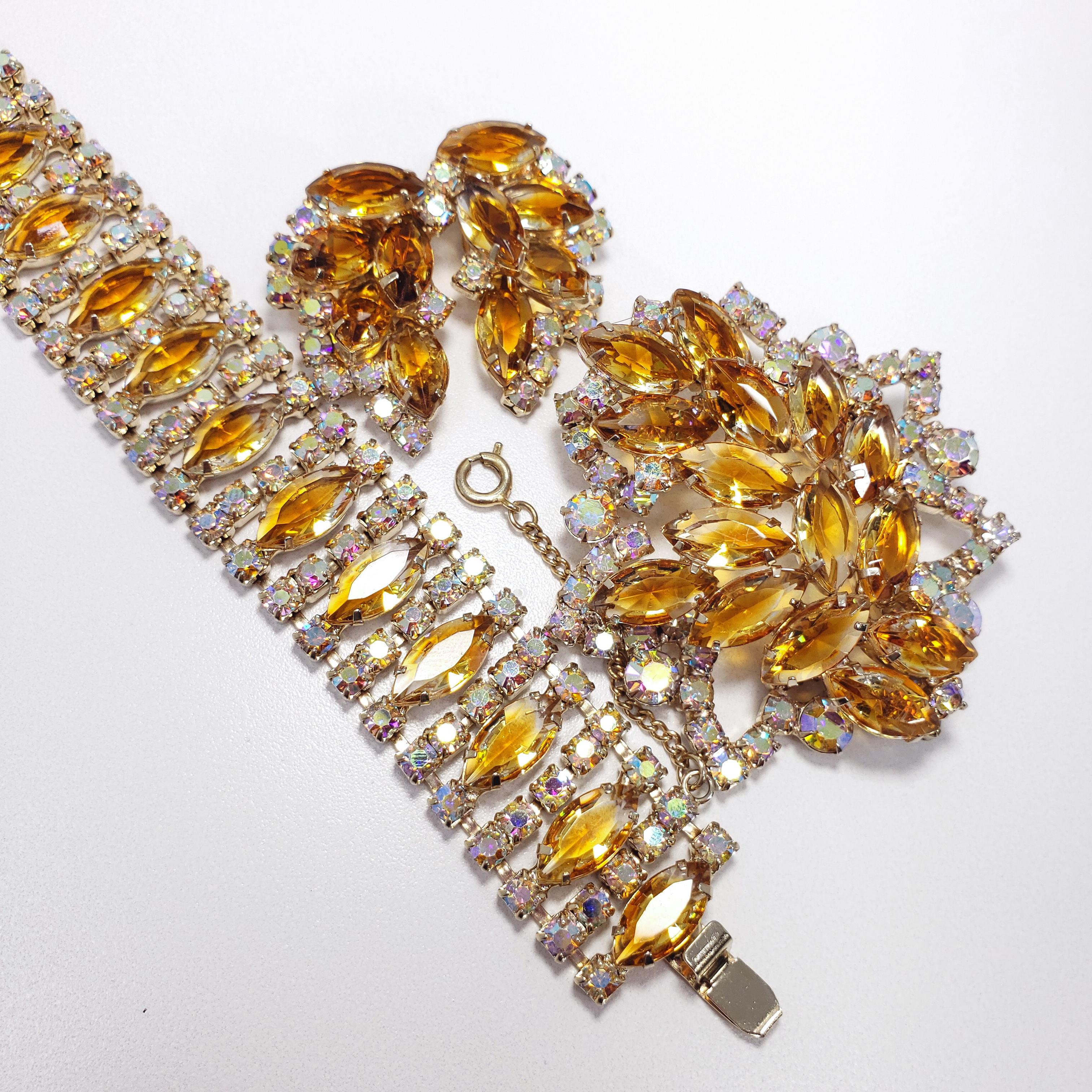 A dazzling demi-parure, featuring a bracelet, earrings, and brooch. Amber colored navettes and aurora borealis chatons, all prong set. Reminiscent of the styles of famous designers such as Weiss and DeLizza Juliana & Elster, with just as much