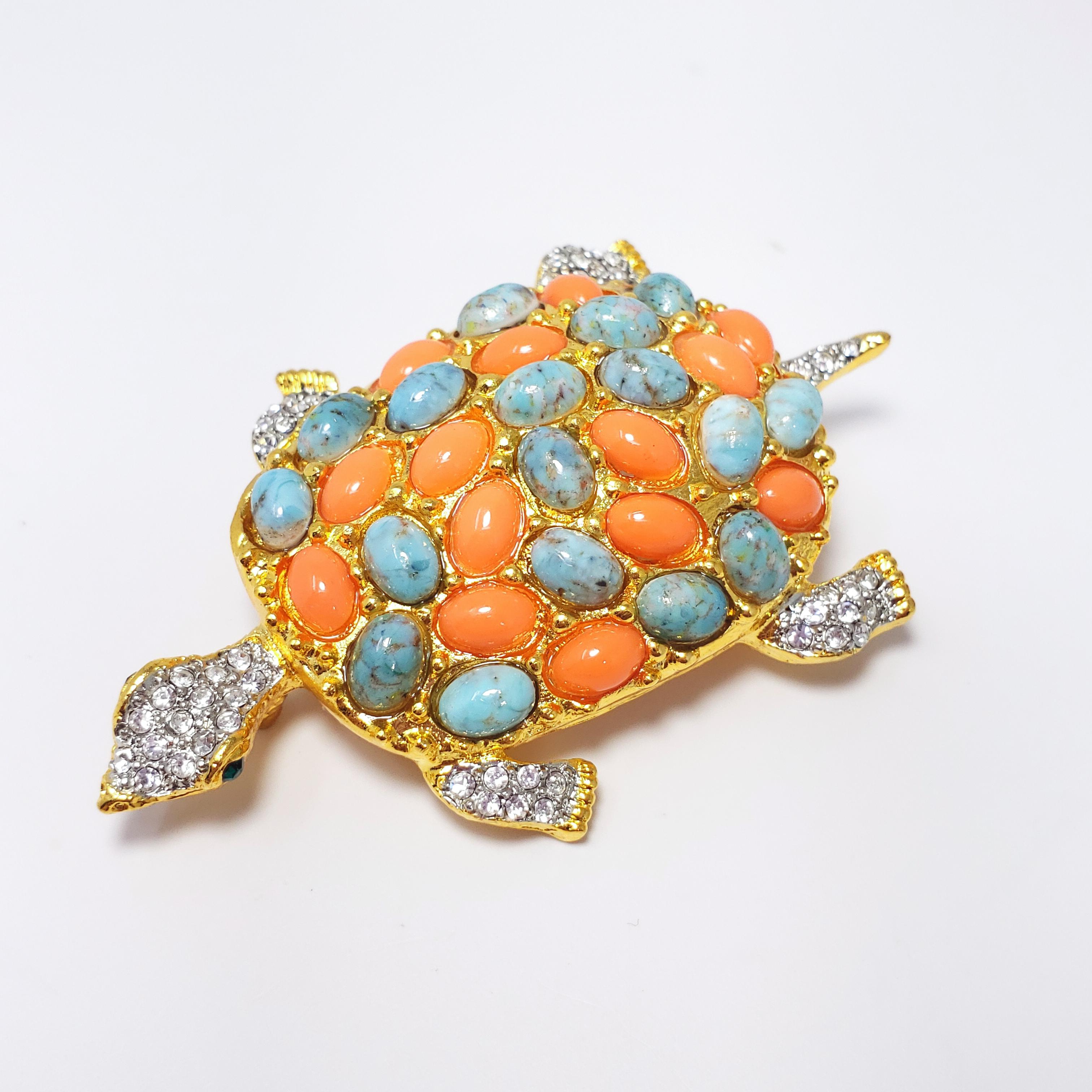 A whimsical turtle decorated with pave resin cabochons in coral and turquoise colors, as well as clear crystals. Set in gold plated metal. By Kenneth Jay Lane.

Hallmarks: Kenneth © Lane