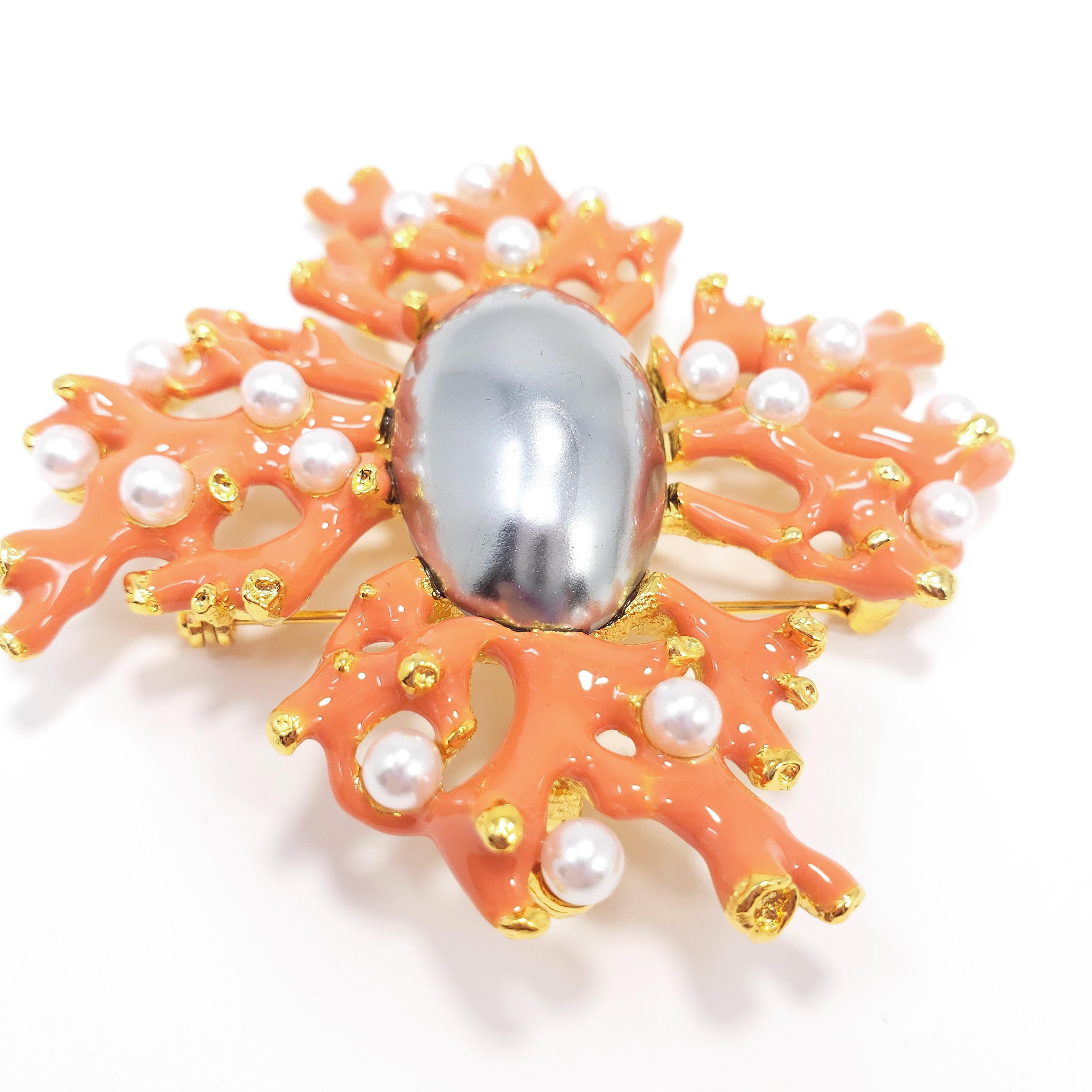 A unique nautical-themed pin/brooch that can also be worn as a pendant. Features coral-enameled branches accented with faux white pearls. An faux elongated gray pearl centerpiece sits in the center.

By Kenneth Jay Lane.

Hallmarks: Kenneth © Lane,