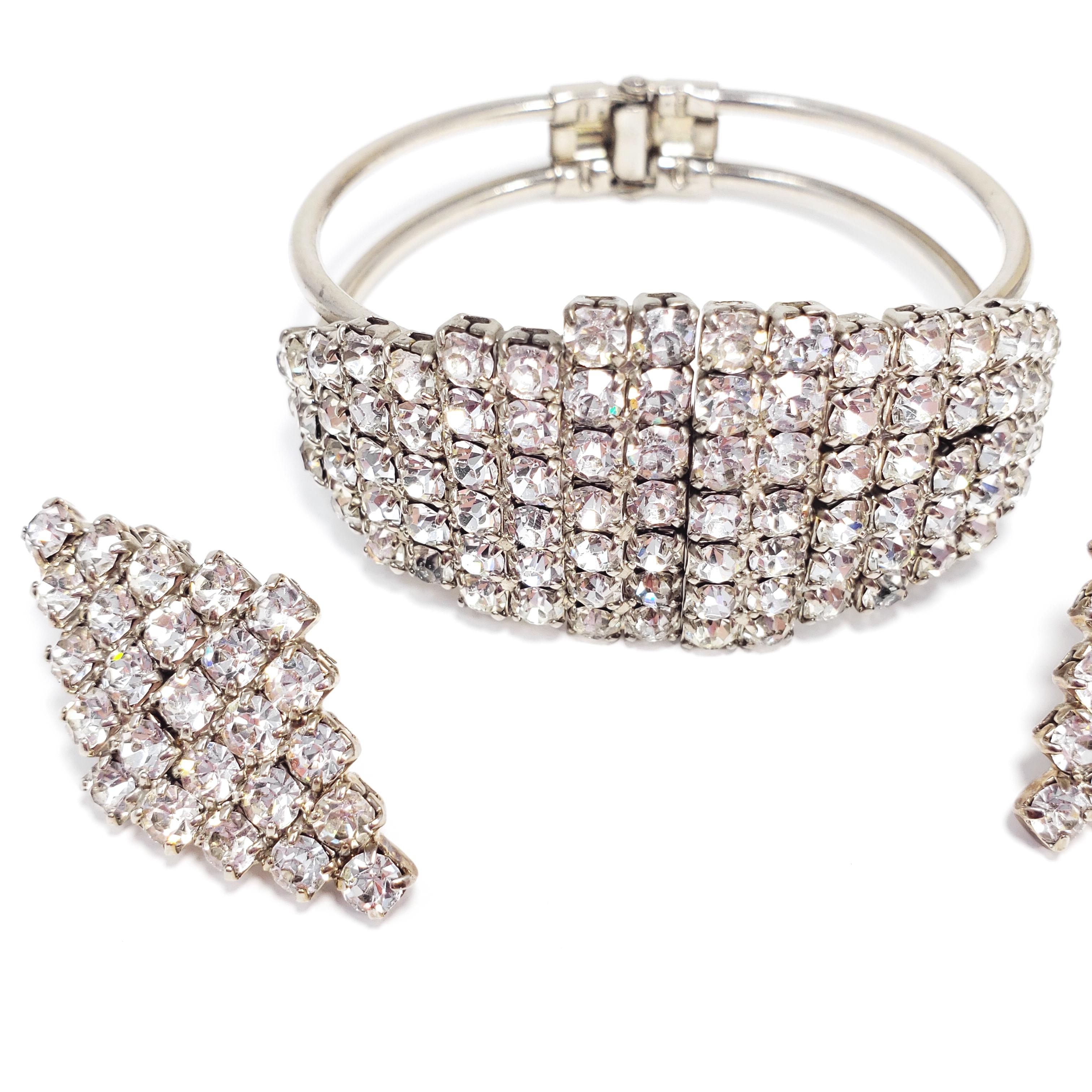 An art-deco set featuring glimmering crystals prong set in a rhodium plated setting. The matching hinged clamper bracelet and clip on earrings are decorated with geometrical pave crystal patterns.

Dimenisions:
Bracelet - 16.25 cm inner