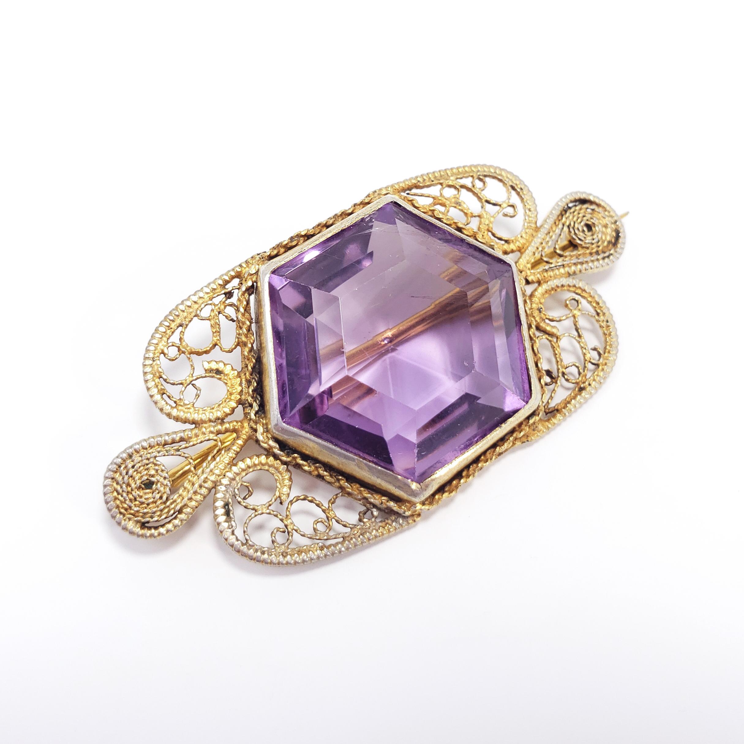 An ornate brooch from the Victorian/Art Nouveau era featuring a genuine, faceted, open-back amethyst bezel set in a textured filigree vermeil setting. 

Amethyst diameter approx 2 cm