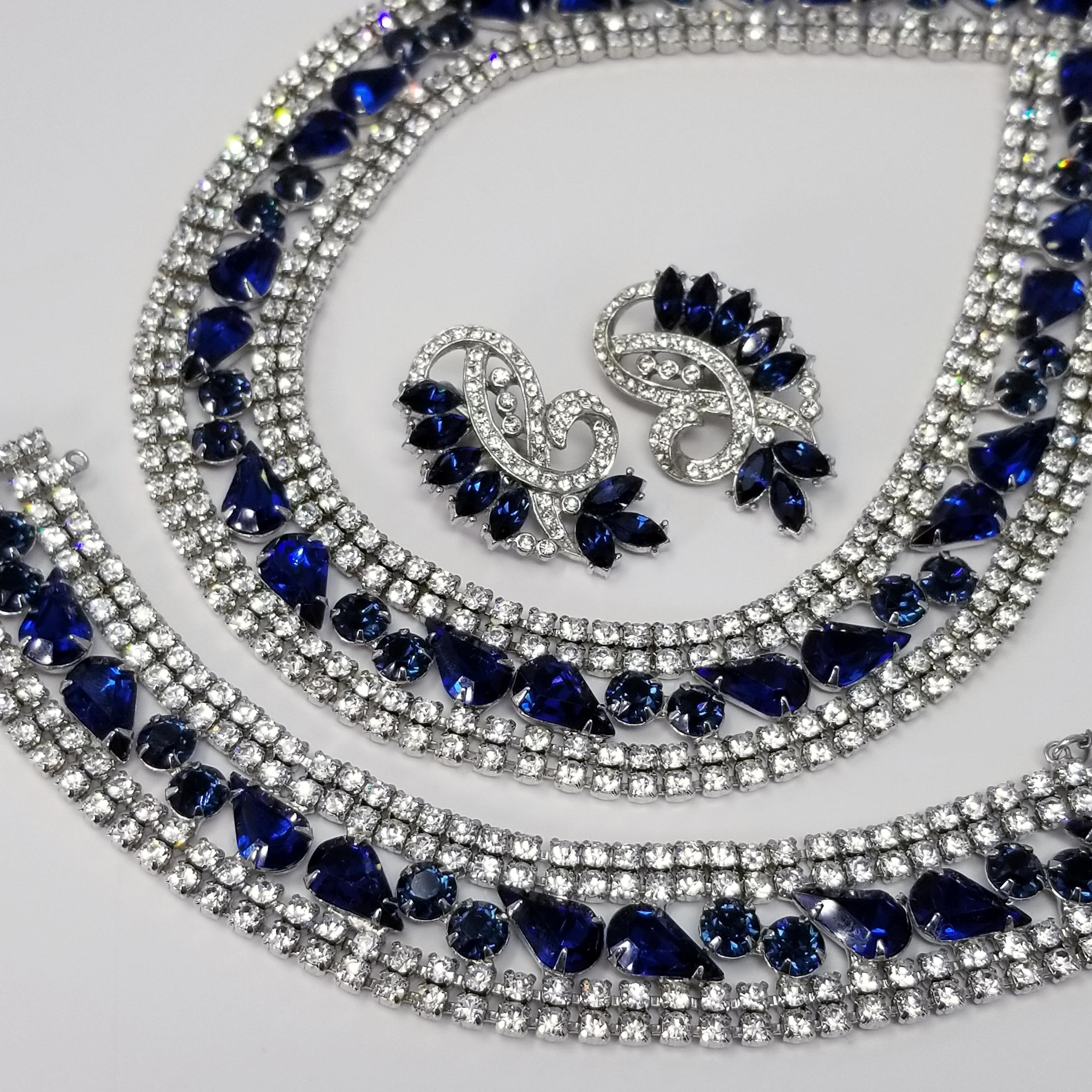 Deep blue faceted sapphire rhinestones and glittering clear rhinestones prong set in rhodium-plated settings. Excellent craftsmanship! All pieces in the set are signed. Ideal condition, never worn. All stones are intact originals. Clips are tight