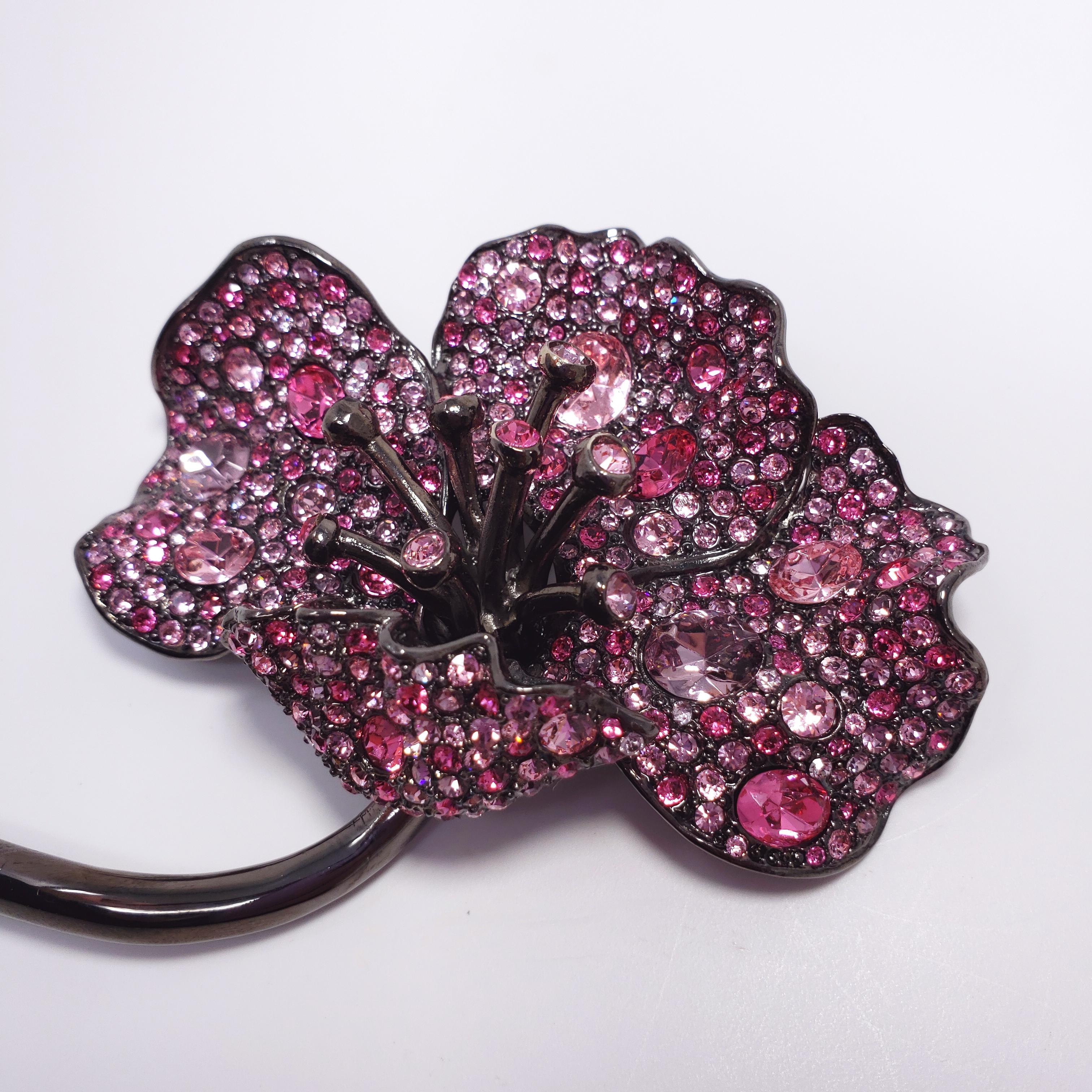 Pave jungle poppy brooch by Kenneth Jay Lane. Exotic rose colors! This dark gray gunmetal-tone flower is decorated with faceted amethyst colored crystals. 

...

Clasp: Pin stem with safety clasp

Metal Type: Dark gray gunmetal tone

Tags, Marks,