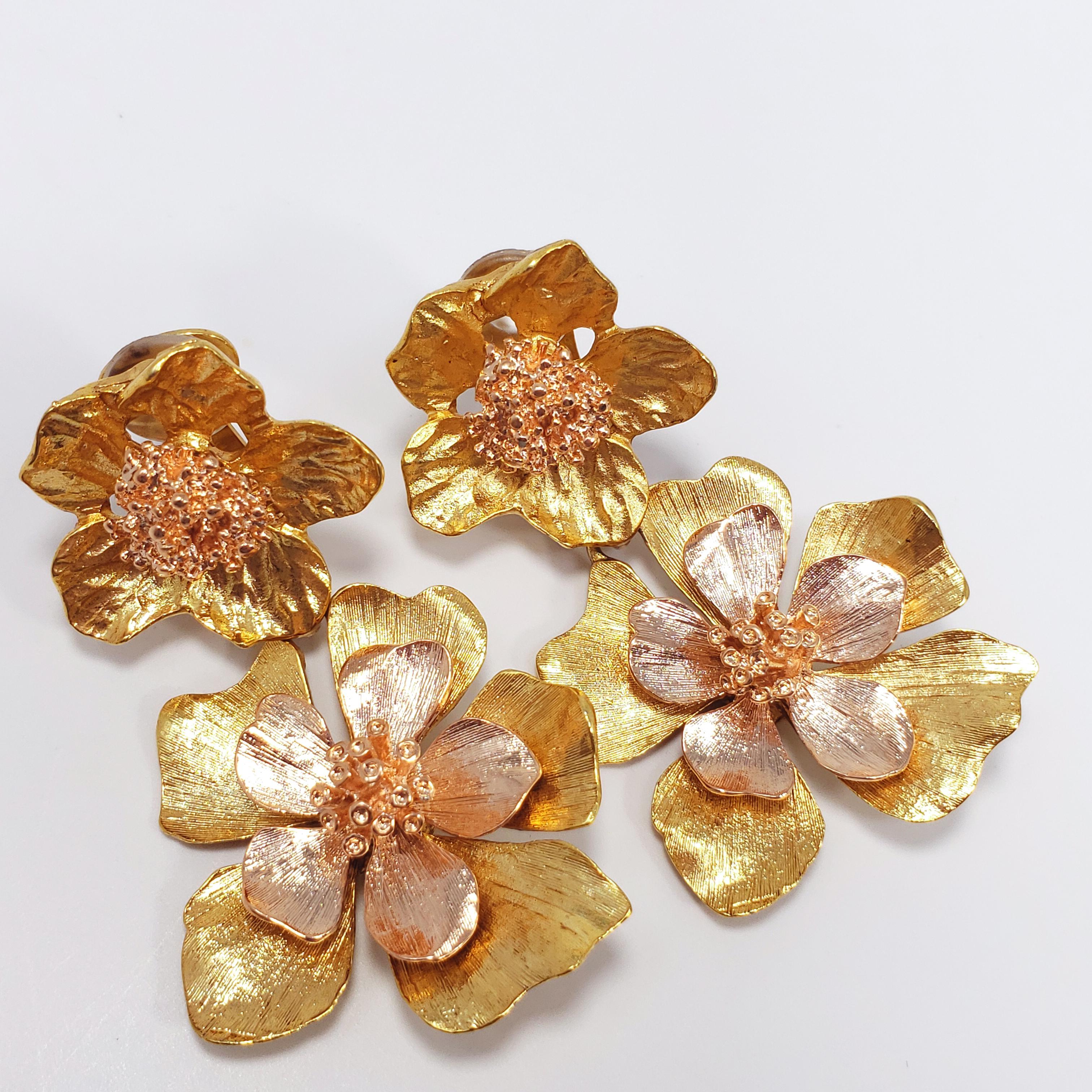 Loud and vibrant dangling clip-ons, featuring two dangling flowers on each earring, plated in 22K bright yellow gold. These Oscar de la Renta gold bold flower earrings definitely live up to their name!

6.5cm in length. The larger flower motif is