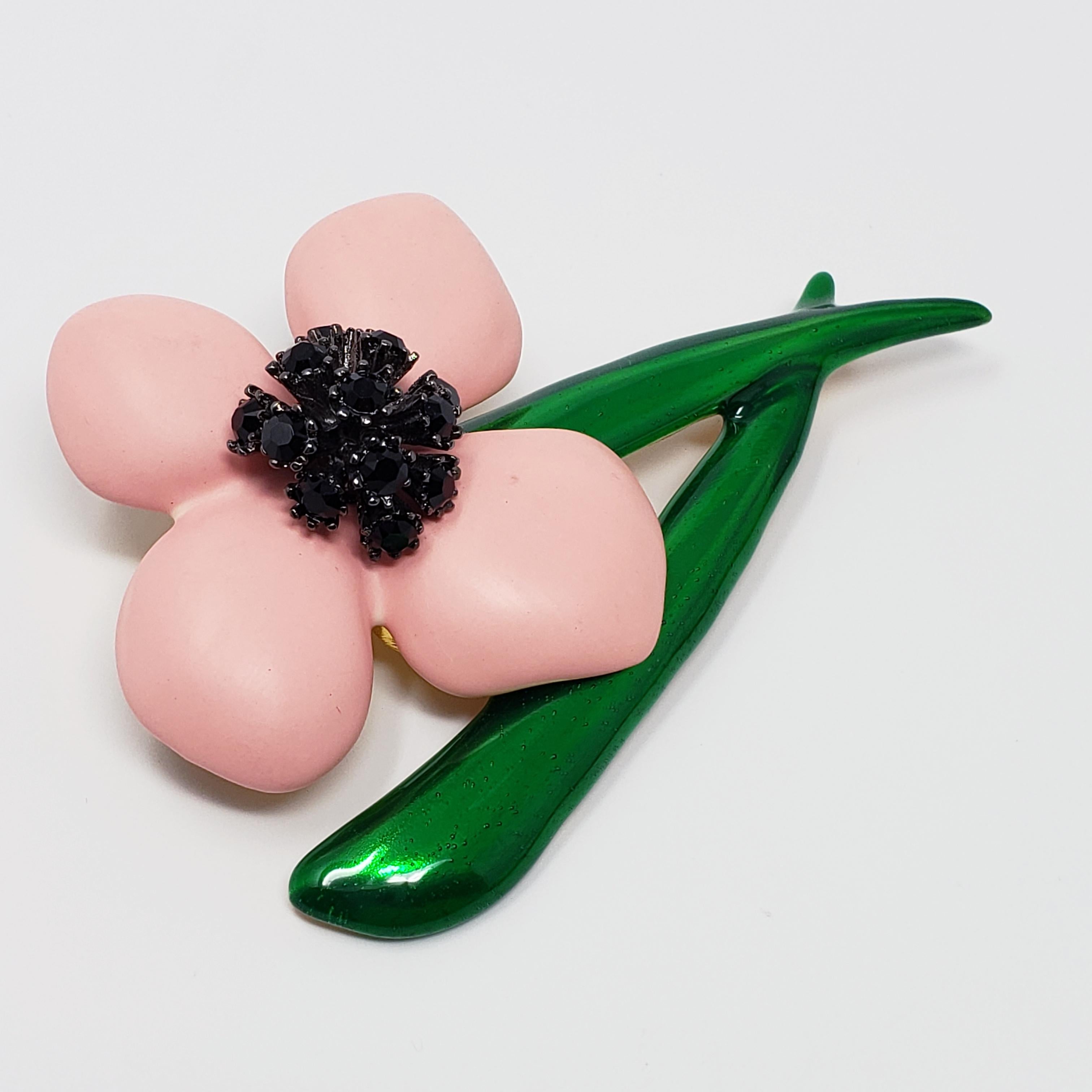 Blooming beauty! A charming brooch from a rare Oscar de la Renta floral collection. The flowers feature soft pink resin petals and a painted green enamel stem. The jet black crystals add striking contrast to this bright and colorful