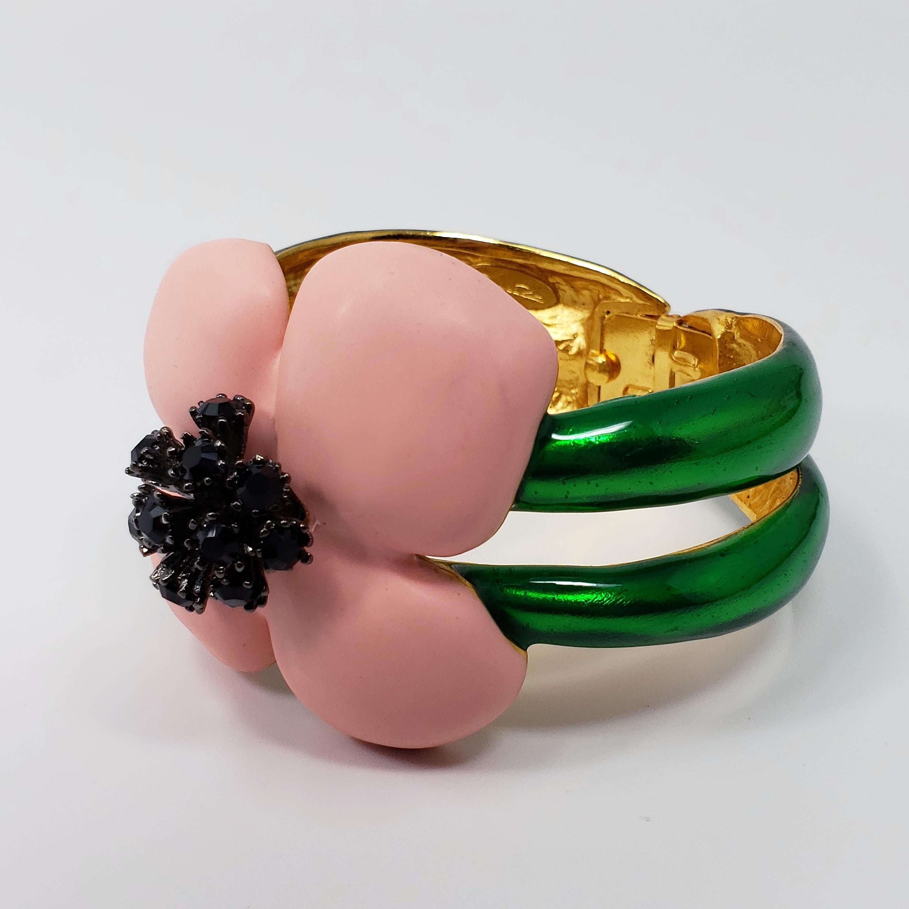Blooming beauty! A charming bracelet from a rare Oscar de la Renta floral collection. The flower features soft pink resin petals on a painted green setting. The jet black crystals add striking contrast to the bright and colorful