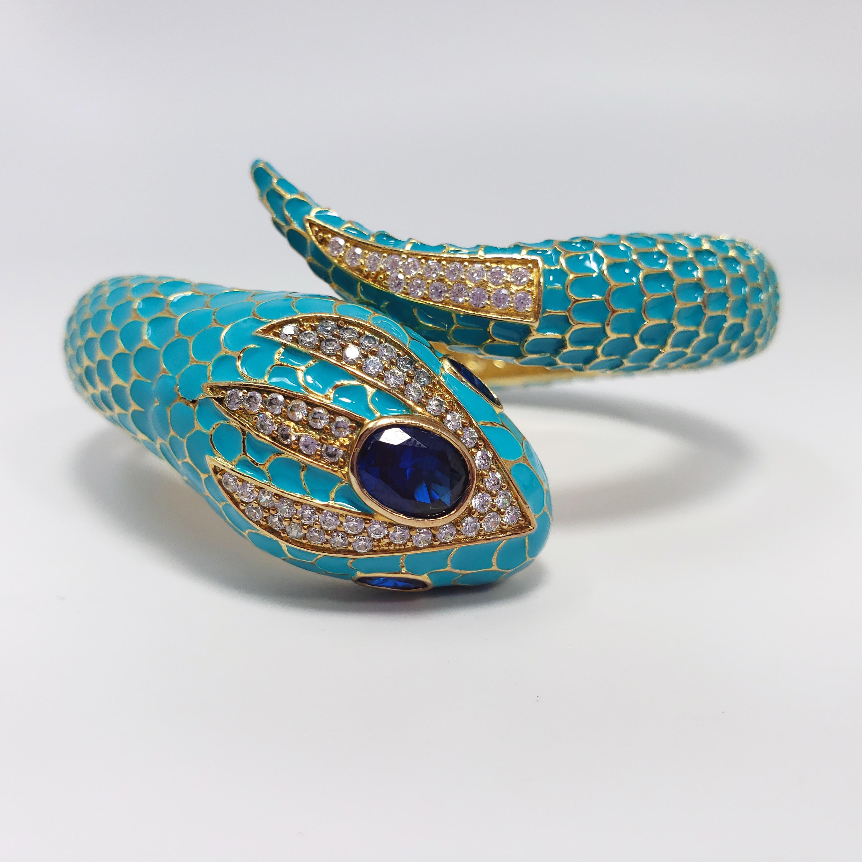 A quirky snake bracelet from Kenneth Jay Lane's CZ collection. Clear and dark sapphire colored cubic zirconia decorate the head, and turquoise-colored enamel scales cover the body for a unique texture. Set on gold plated metal.

Hallmarks: CZ by