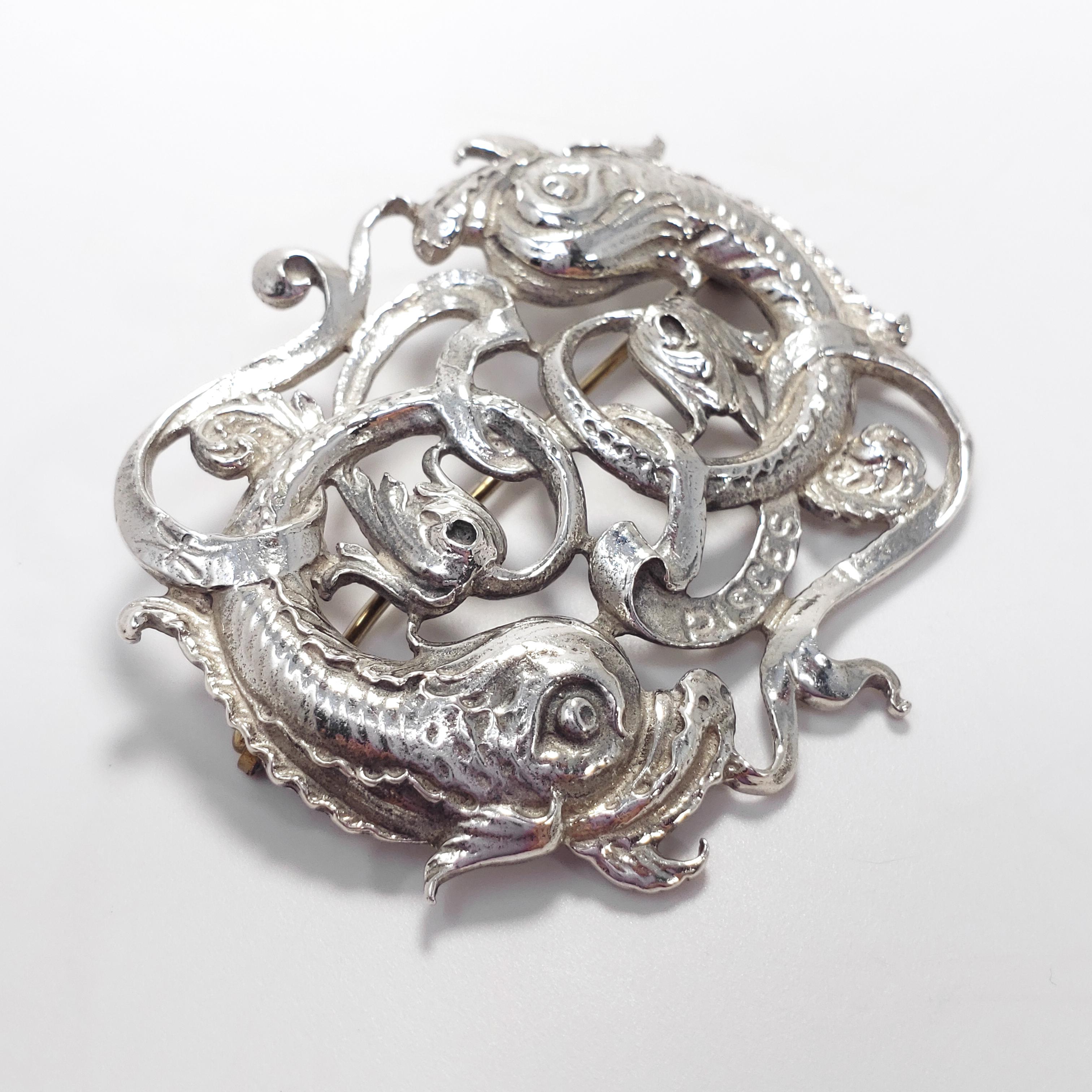 A perfect pin for a Pisces! Features the two iconic Pisces fish adorned with various motifs, all in sterling silver. From Guglielmo Cini's sterling silver collection.

Hallmarks: Sterling by Cini