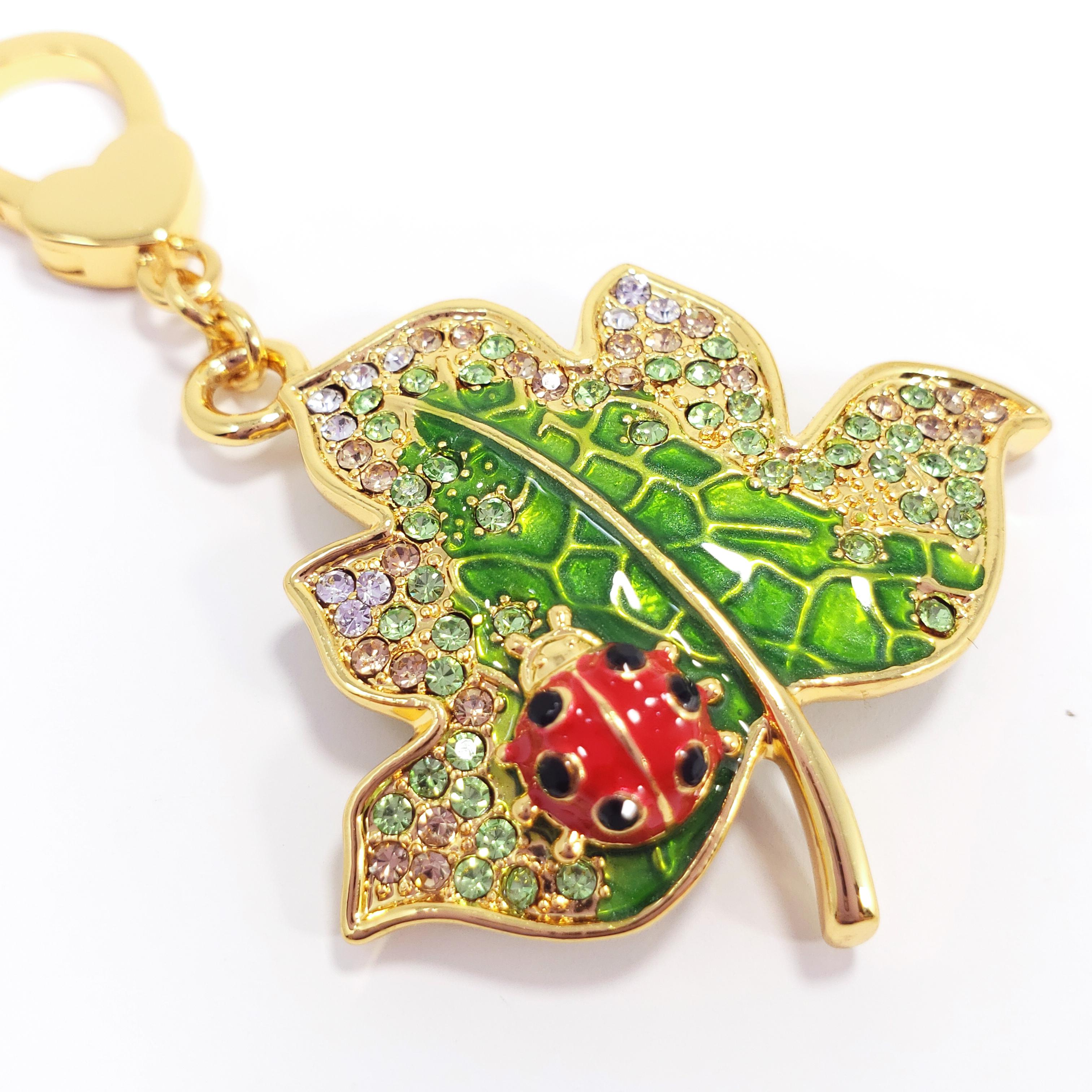 A whimsical leaf and ladybug charm, painted with green, red, and  black enamel, and accented with colorful crystals. Can be worn as a bracelet charm, a necklace pendant, or in a multitude of other creative ways.

Hallmarks: Jay, Jay Strongwater,