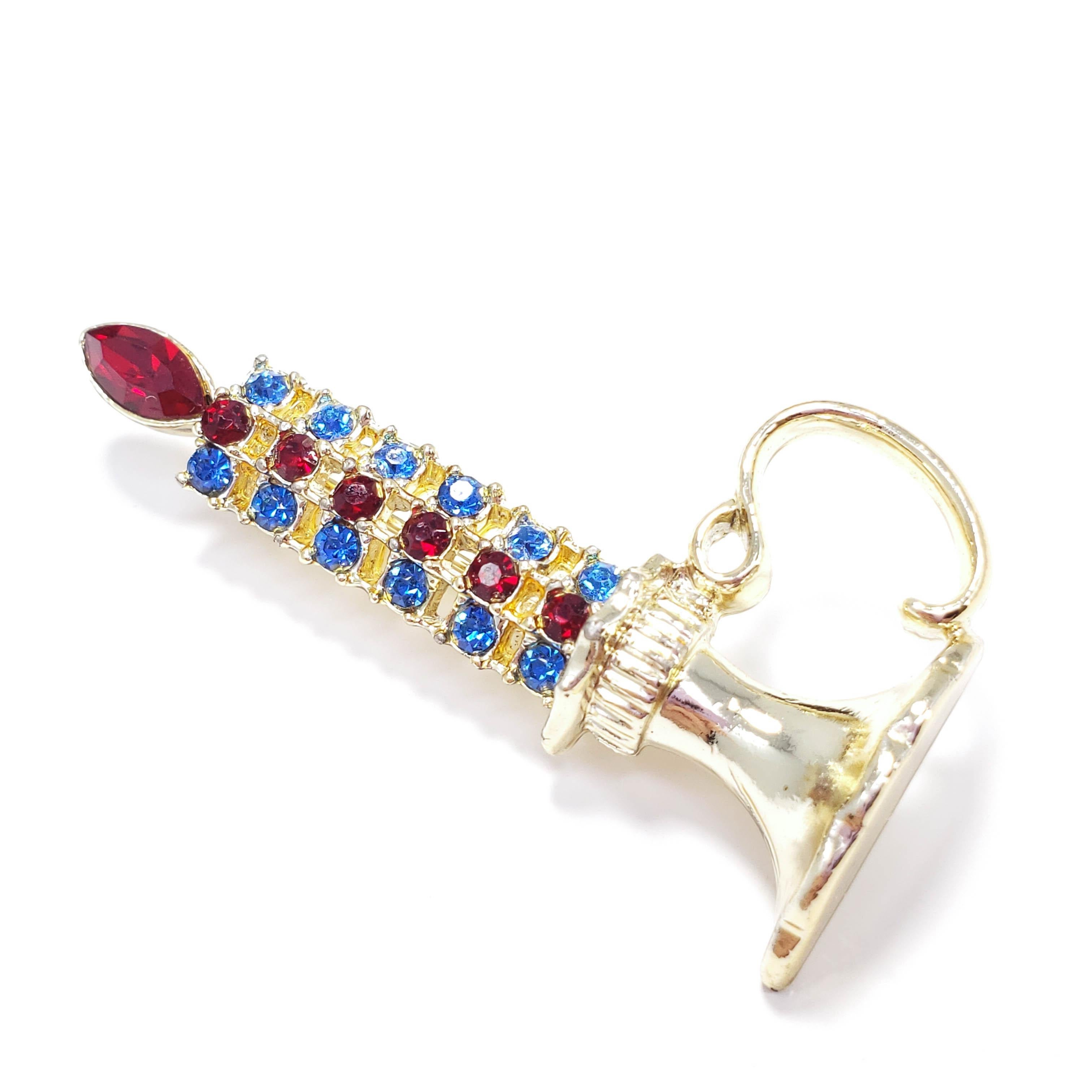 A whimsical candlestick pin/brooch, featuring blue and red crystals set in gold-plated metal. Signed © Emmons.

Emmons Jewelry was founded by Charles Stuart, the same man who founded Sarah Coventry. Emmons Jewelry went out of business in 1981,