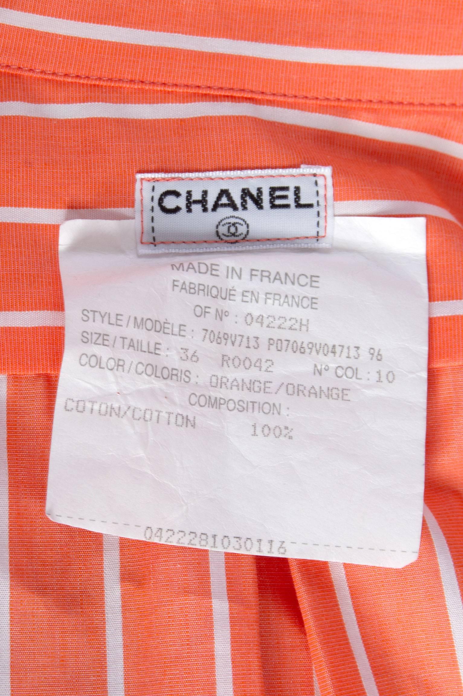 A lovely 1980s tangerine Chanel cotton pajamas with white vertical stripes. The ensemble consist of a loose fitted shirt and a pair of shorts. The shirt has one buttoned cuffs, two breast pockets with a one buttoned flap closure and closes down the