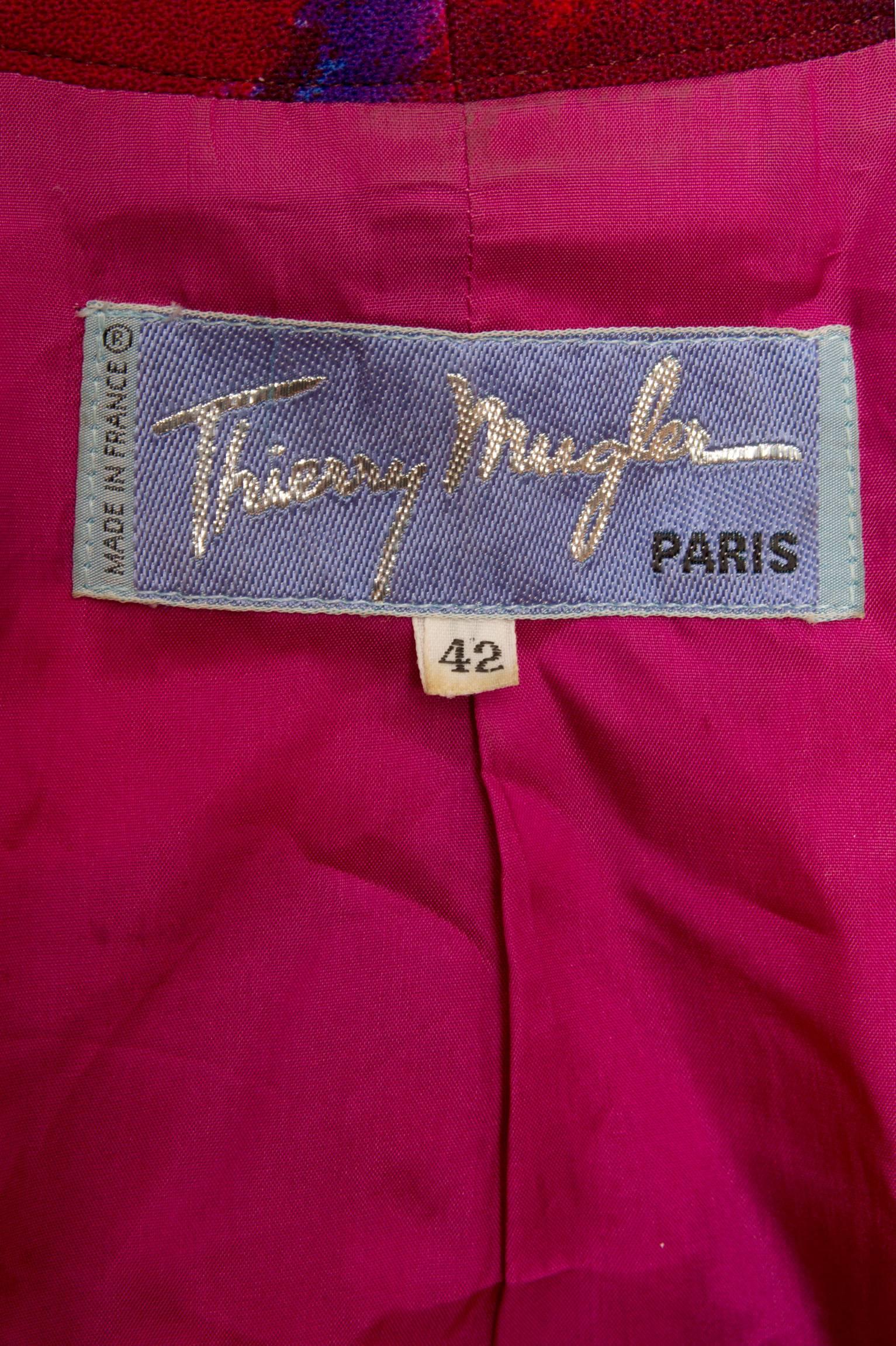 A stunning 1980s Thierry Mugler wool blazer with an asymmetrical hemline and a push button closure. The blazer have long tapered sleeves with structured shoulders held in place by shoulder-pads. The color combination is absolutely stunning and the