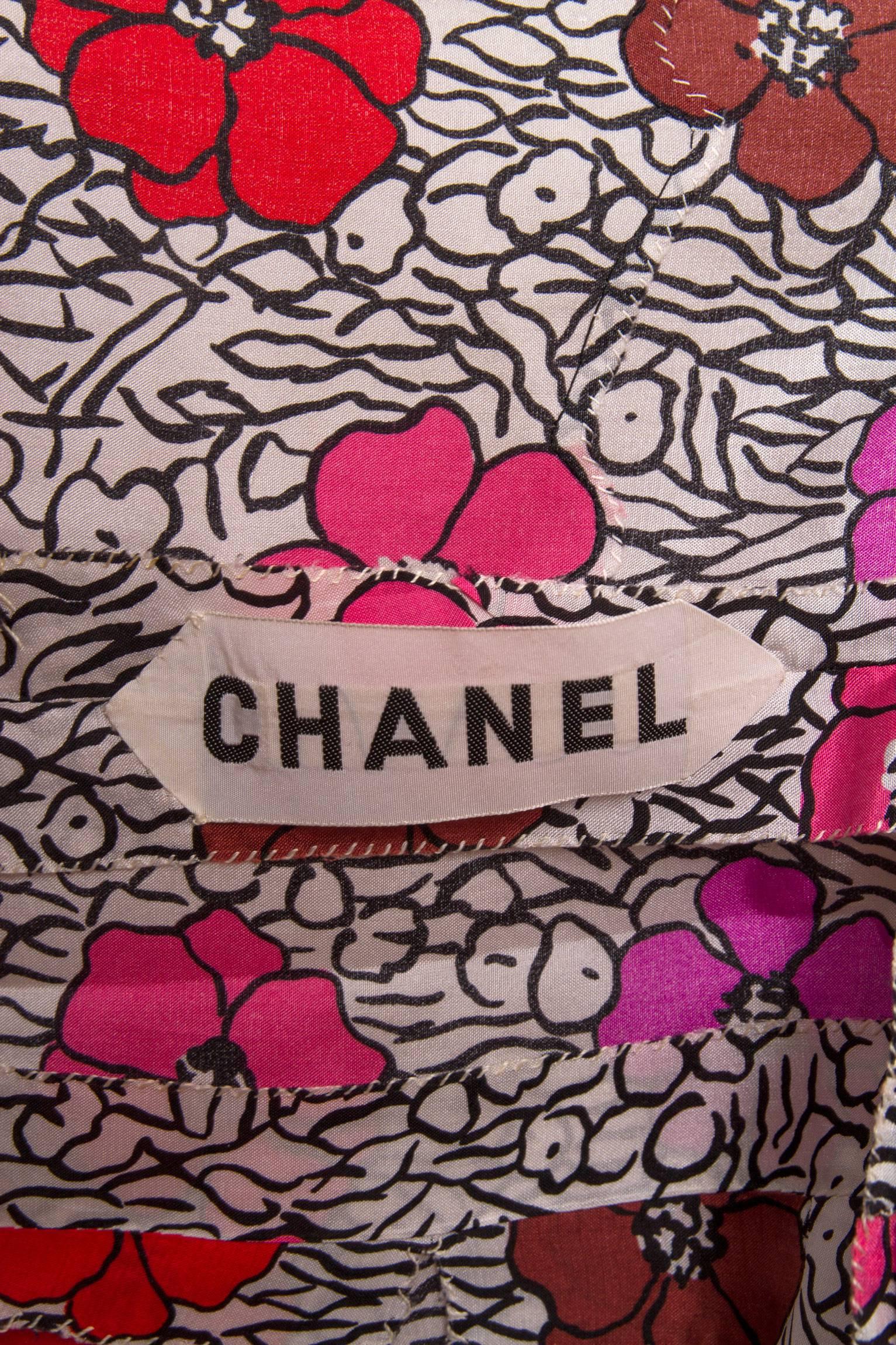 A stunning 1960s Chanel haute couture floral print silk dress with short sleeves and pleated hem. The dress have a high neckline that can be tied in the back into a luscious bow. The floral print is held in bright pink, red and brown and stand as a
