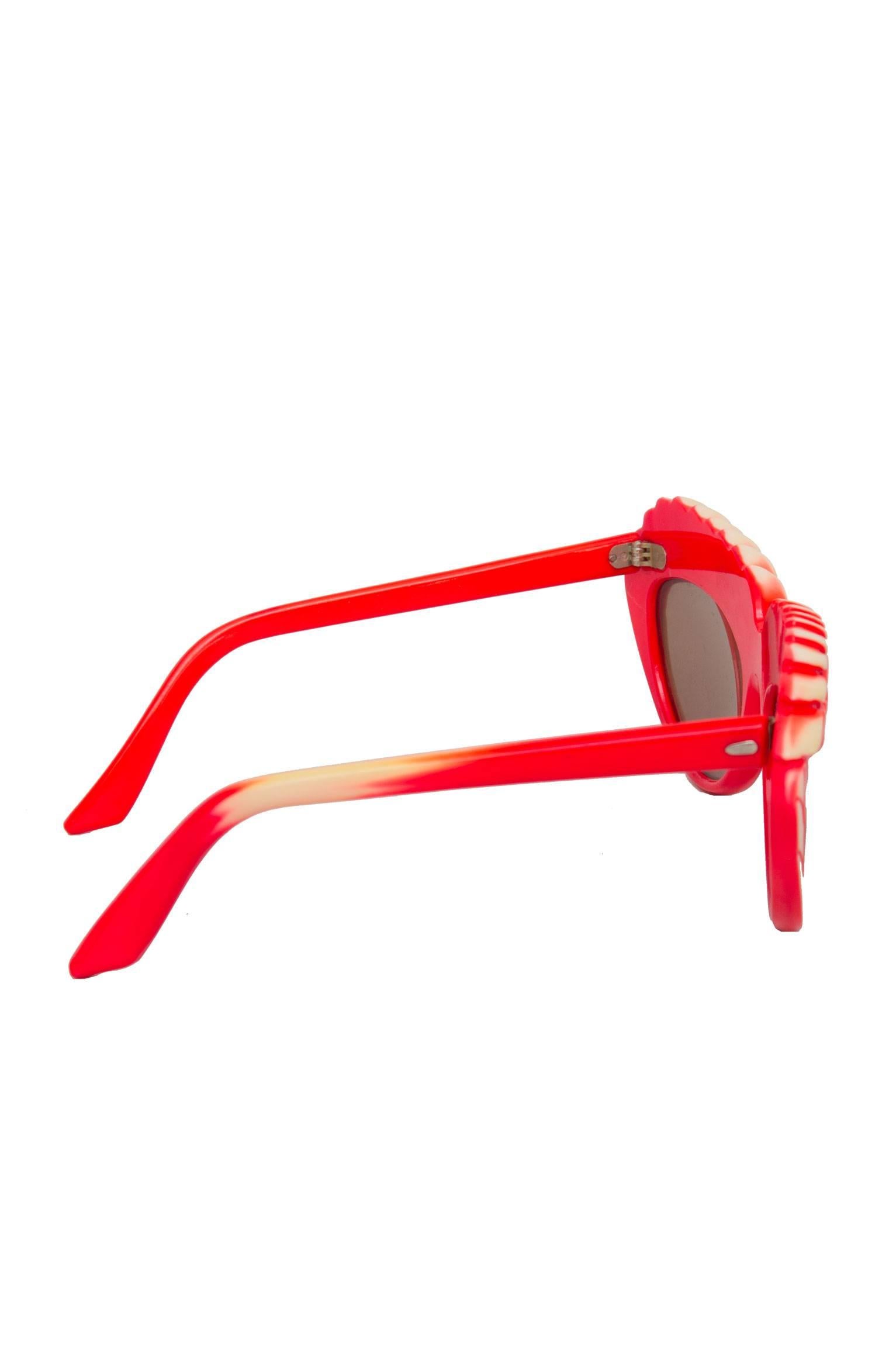 A rare pair of 1980s bright red Isabel Canovas sunglasses with brown tinted lenses  and a detailed frame, where two yellow barley heads stretch across each lens. 
