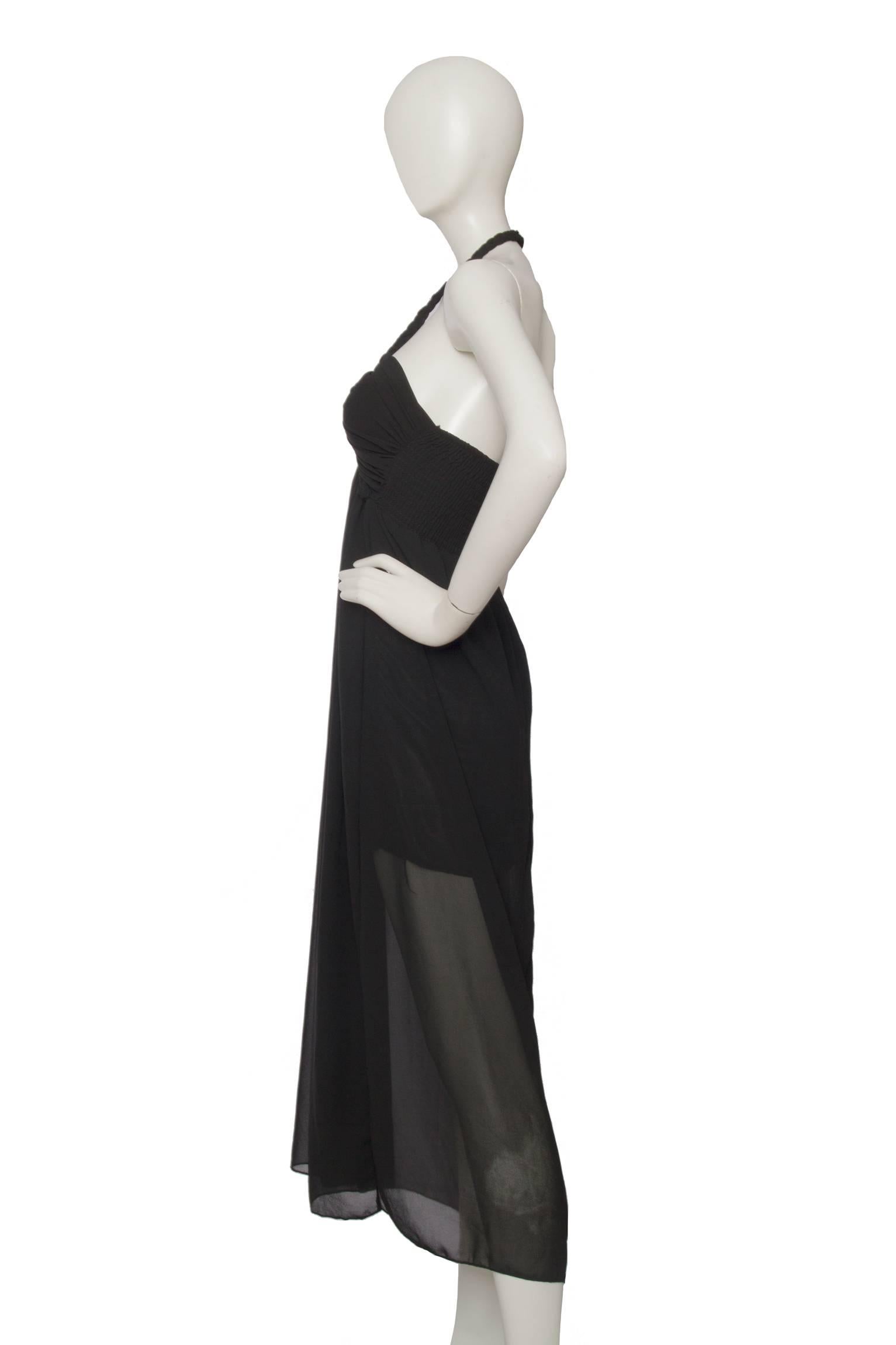A classic 1970s black halterneck evening dress with a fitted rouched bodice and a double layered skirt with a sheer overlay. The braided halterneck strap encase the bodice and extents into an elasticated insert at the back. 

The size of the dress