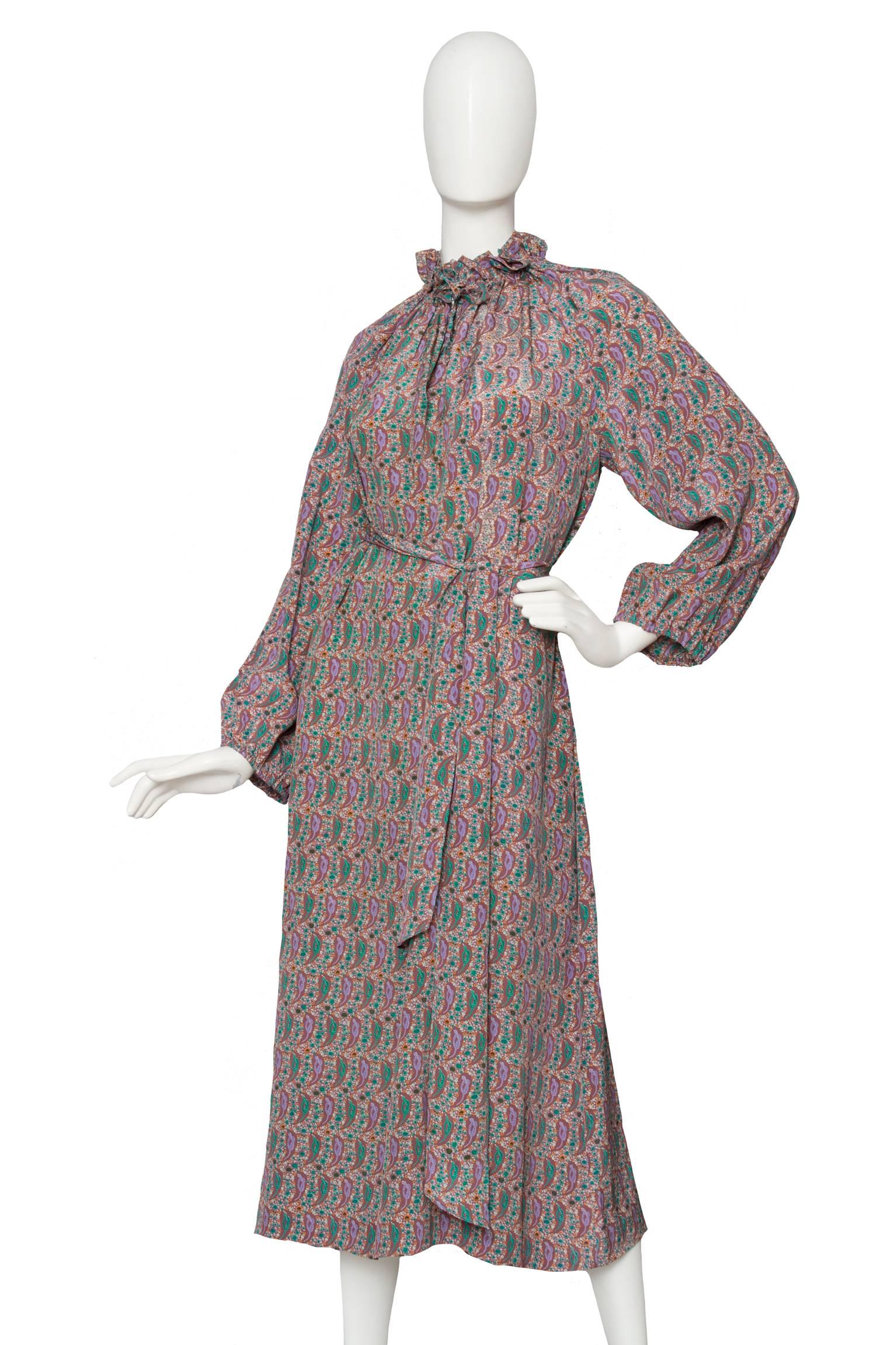 A late 1970s Hanae Mori silk day dress with a beautiful green, purple & orange paisley print. The dress has long voluminous sleeves with elasticated cuffs and a ruffled collar with a small ribbon closure to the front. A detachable silk is worn