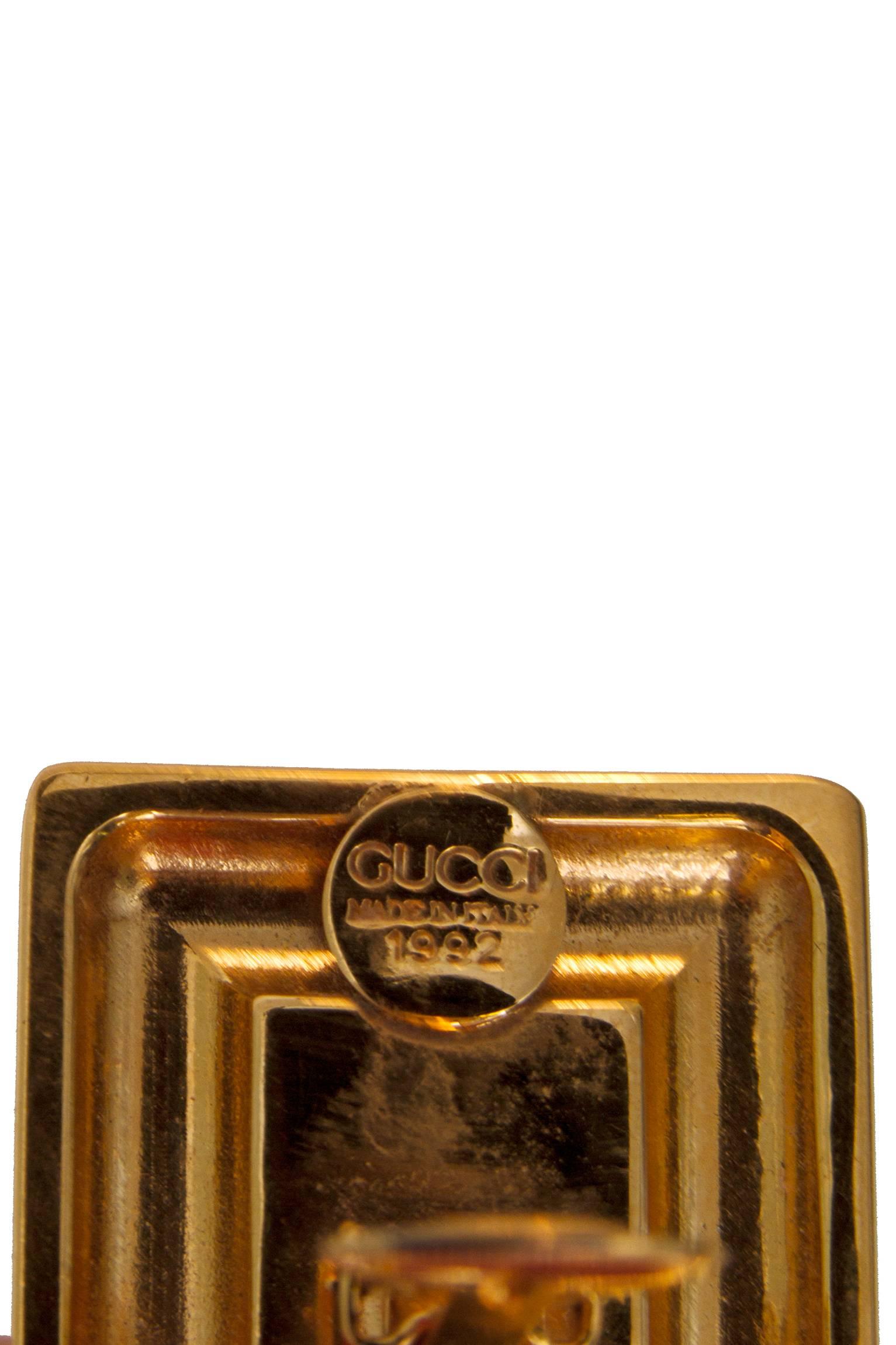 A pair of gold plated Gucci clip-on earrings dating from 1992. The square earrings have a round double 'G' logo set in center. The logo measures 1.5 by 1.5 cm. 

The earrings are stamped: Gucci, Made in Italy, 1992