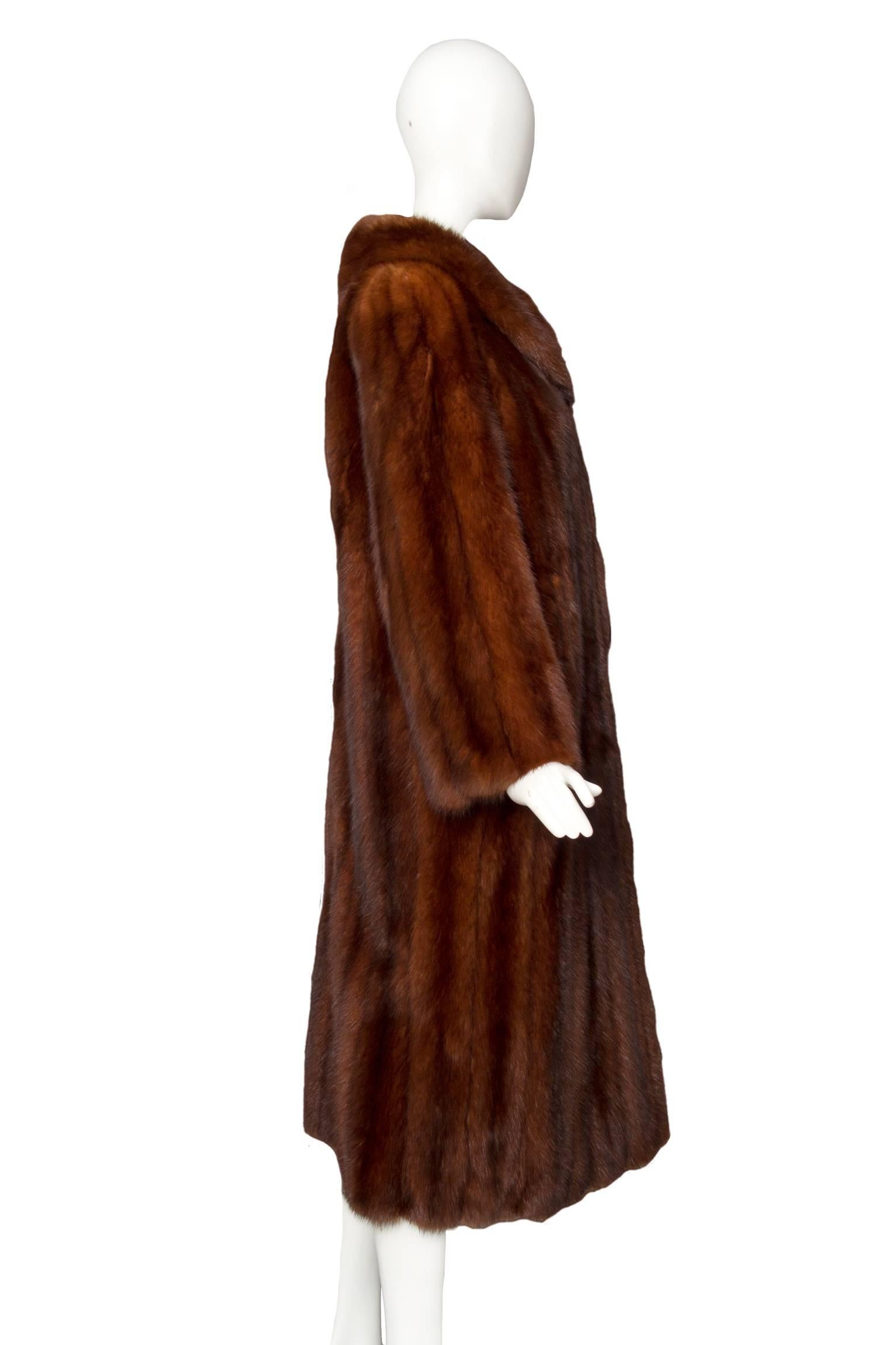 A stunning 1980s knee-length brown Russian sable fur coat with side pockets and dark leather paneling underneath each arm. The elegant coat is fully lined with a light brown jacquard woven silk and has a small leather trimmed slit is situated at the