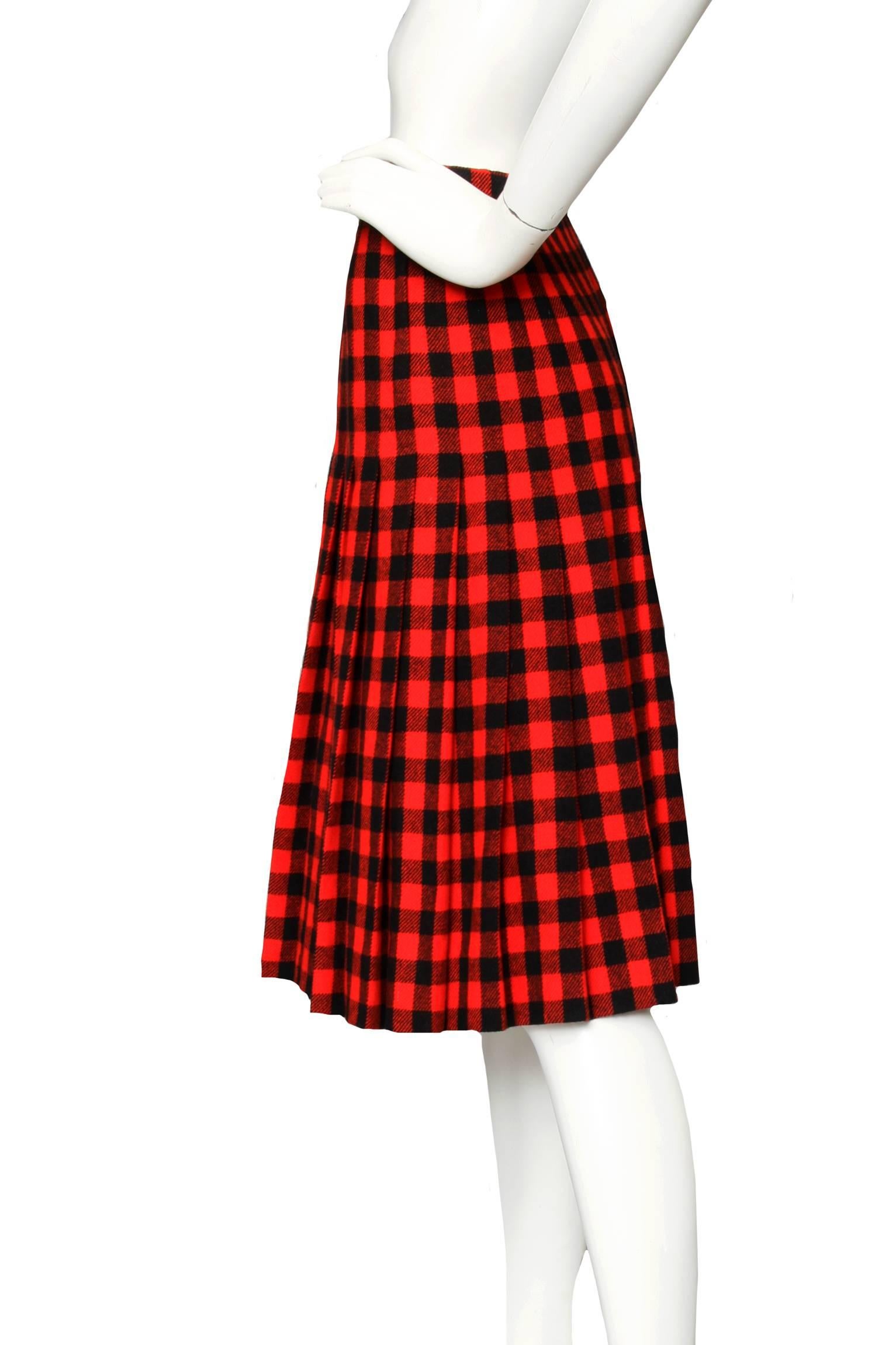 A gorgeous 1960s Givenchy haute couture red and black plaid wool a-line wool skirt with pleats. The skirt is fully lined and has a back zipper and hook-and-eye closure. 

The size of the skirt corresponds to a modern size Medium. 

