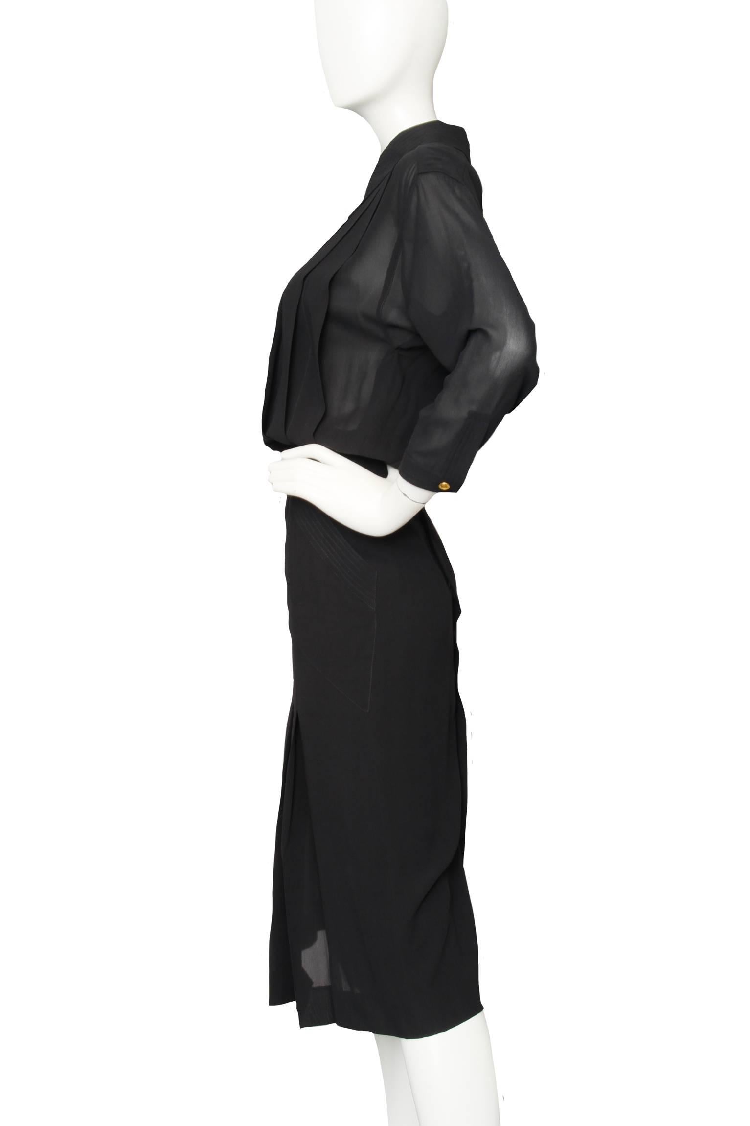 A gorgeous 1990s black Chanel silk day dress with semi-sheer sleeves with one buttoned cuff, a pleated midi-length overskirt, and a pleated blouse. In the back, the dress has a full button closure that extends to a collar with stitching details. The