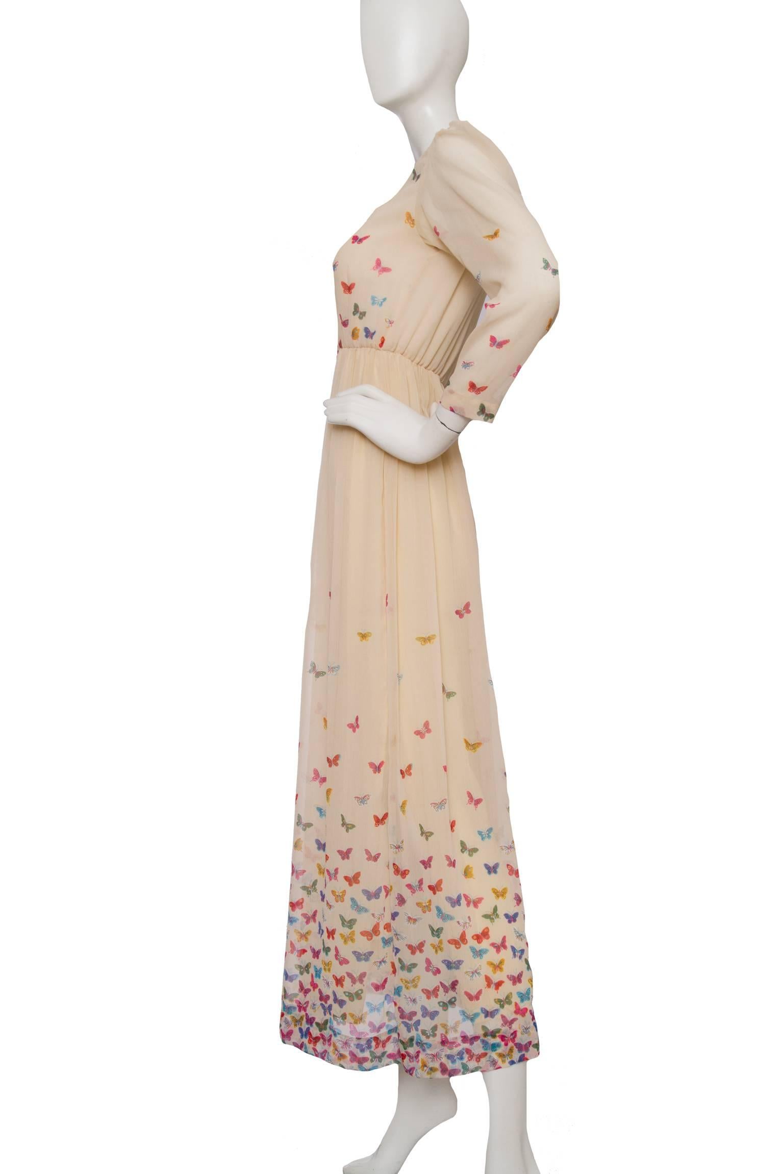 A delicate 1970s Hanae Mori beige silk dress with a nipped in elasticated waist, a sheer blouse and a multi-layered & pleated floor-length skirt. The dress has long tapered sleeves, a silk satin trim along a scoop neckline and a buttoned down