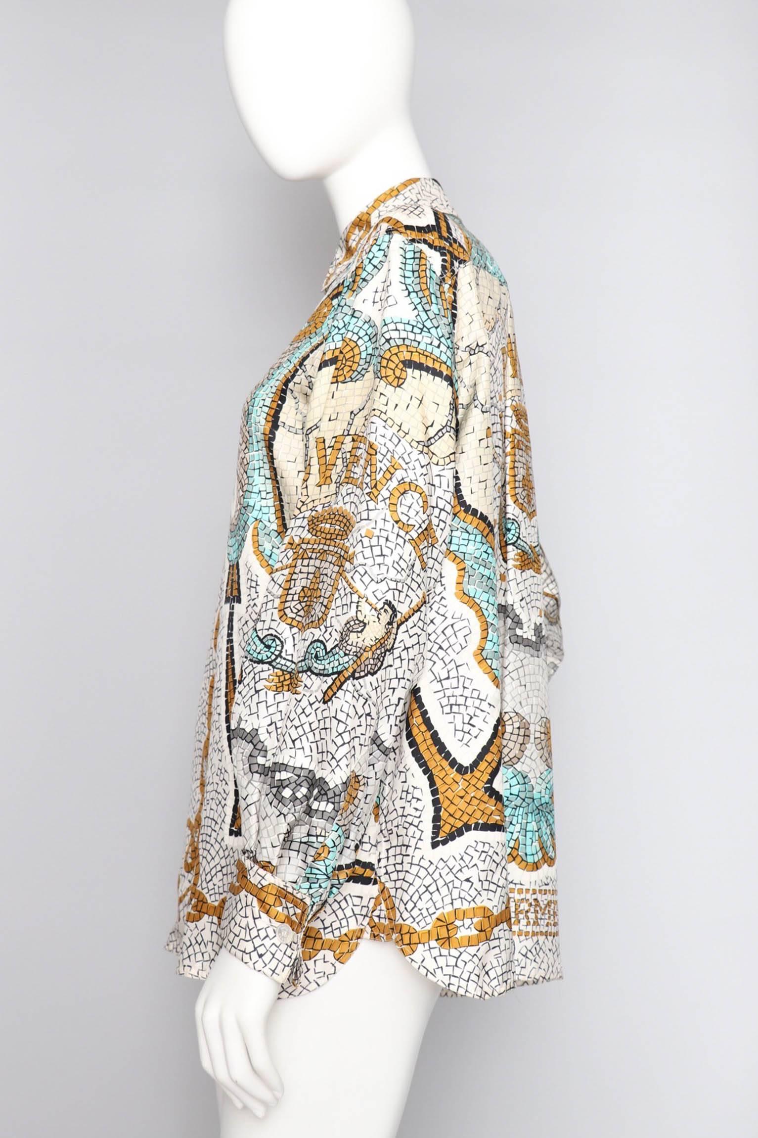 An absolutely incredible Hermés silk twill blouse issued in 1956 themed "Provence" by Hugo Grygkar. The mosaic print is held in Mediterranean colors of turquoise and yellow with black and white accents. Both Provence and Hermes can be