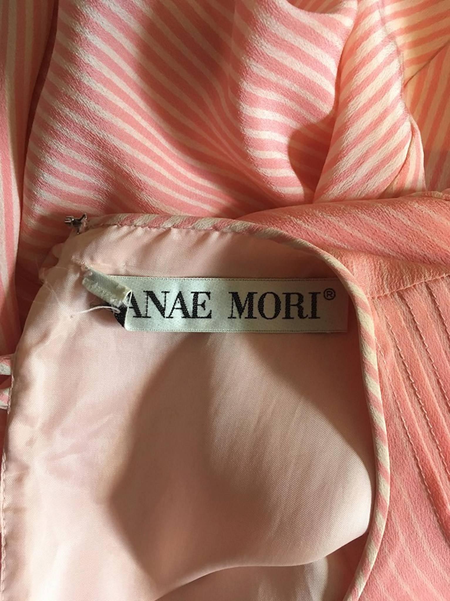 A fabulous 1980s Hanae Mori pink and white striped silk dress with voluminous sleeves with fitted cuffs, a round neckline, and pleating down the left shoulder. The dress is unlined and close in the back with a buttoned closure. 

The size of the