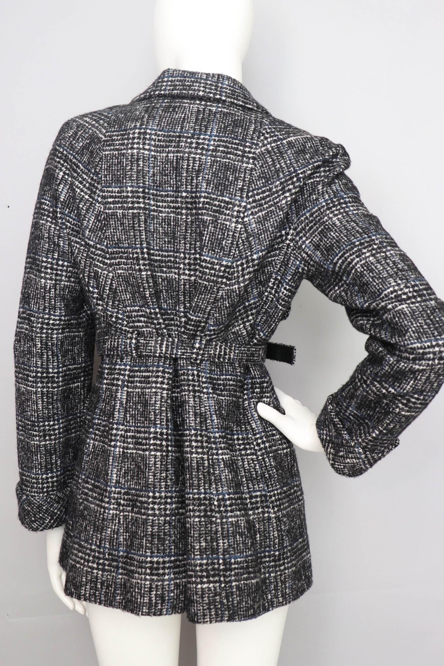 A classic 1990s tartan Chanel wool jacket with a deep v-front and a button-down front. The jacket has a matching waist belt with a silver Chanel engraved buckle and two patch pockets situated on both sides, one on each breast and one along each