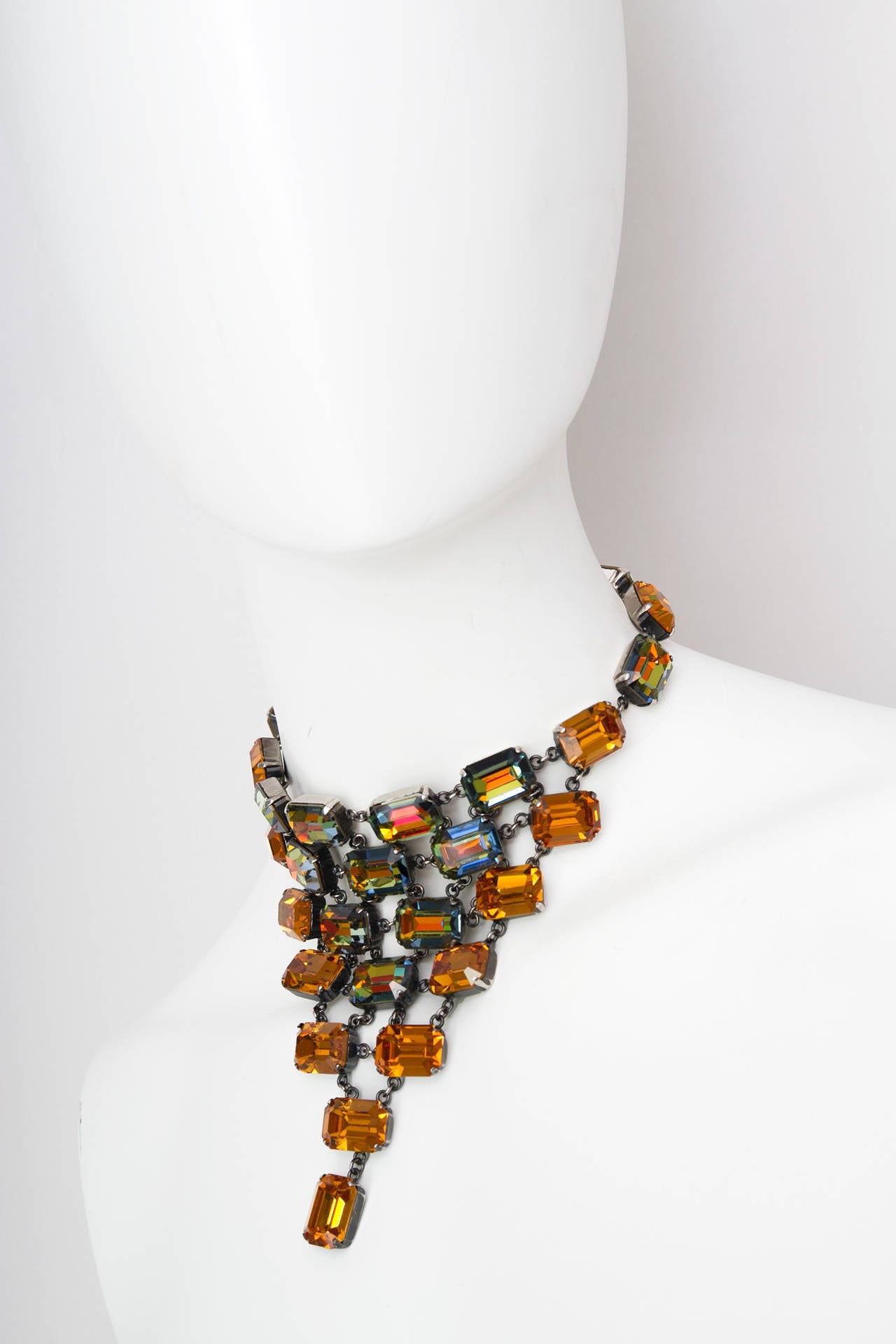 A 1978 Yves Saint Laurent haute couture necklace, signed, designed by Roger Schemama for YSL. With round edged squared glass stones that in the front has a triangular chain grid shape, the stones variates in colour and transcends between yellow,