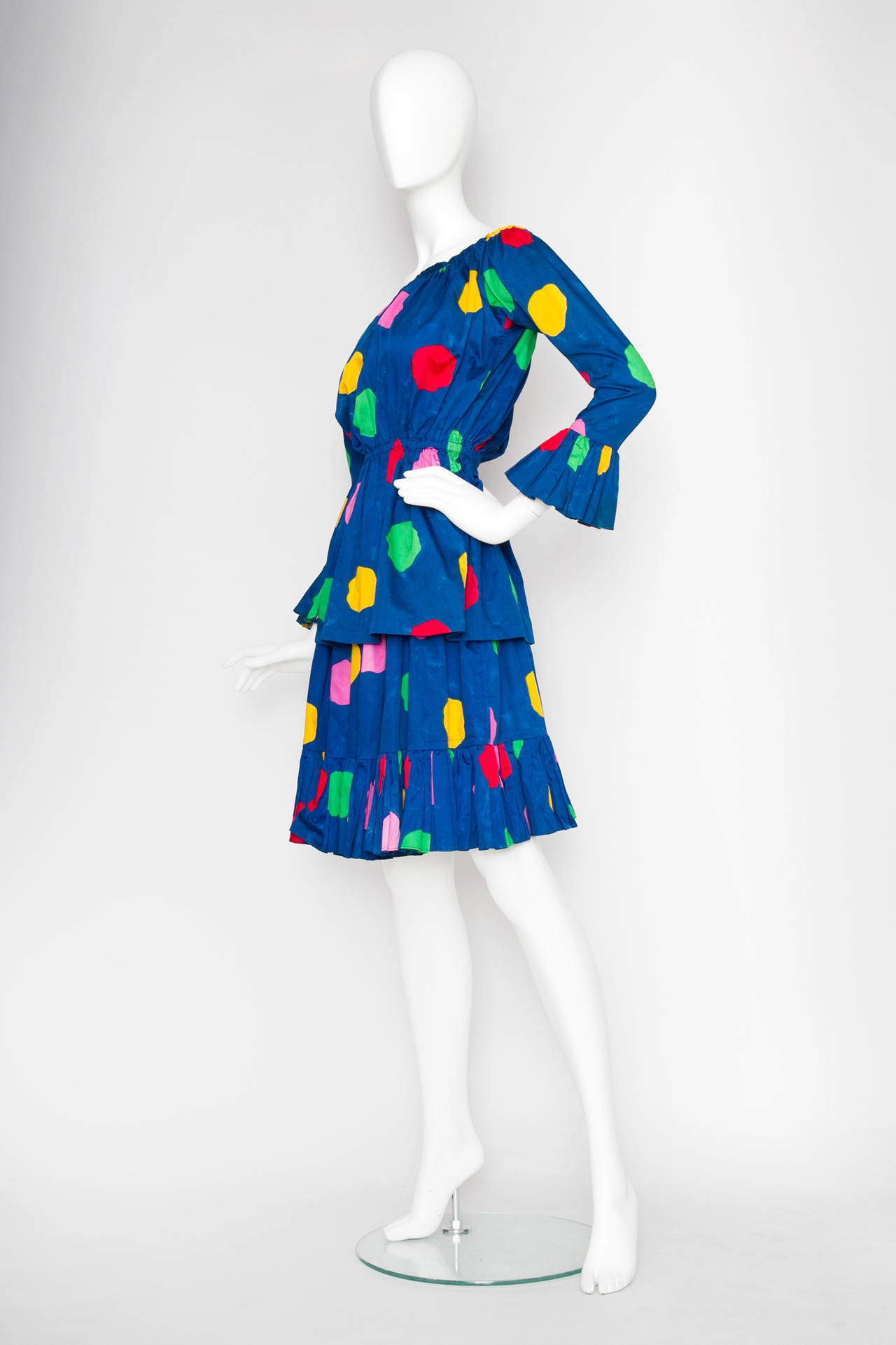 A 1980s bright blue Yves Saint Laurent peasant skirt dress with festive multicolored polka-dot print. A separate off-shoulder blouse with an elasticated waist, bell sleeves and a knee-length skirt with an elasticated waistband around the hip.

The
