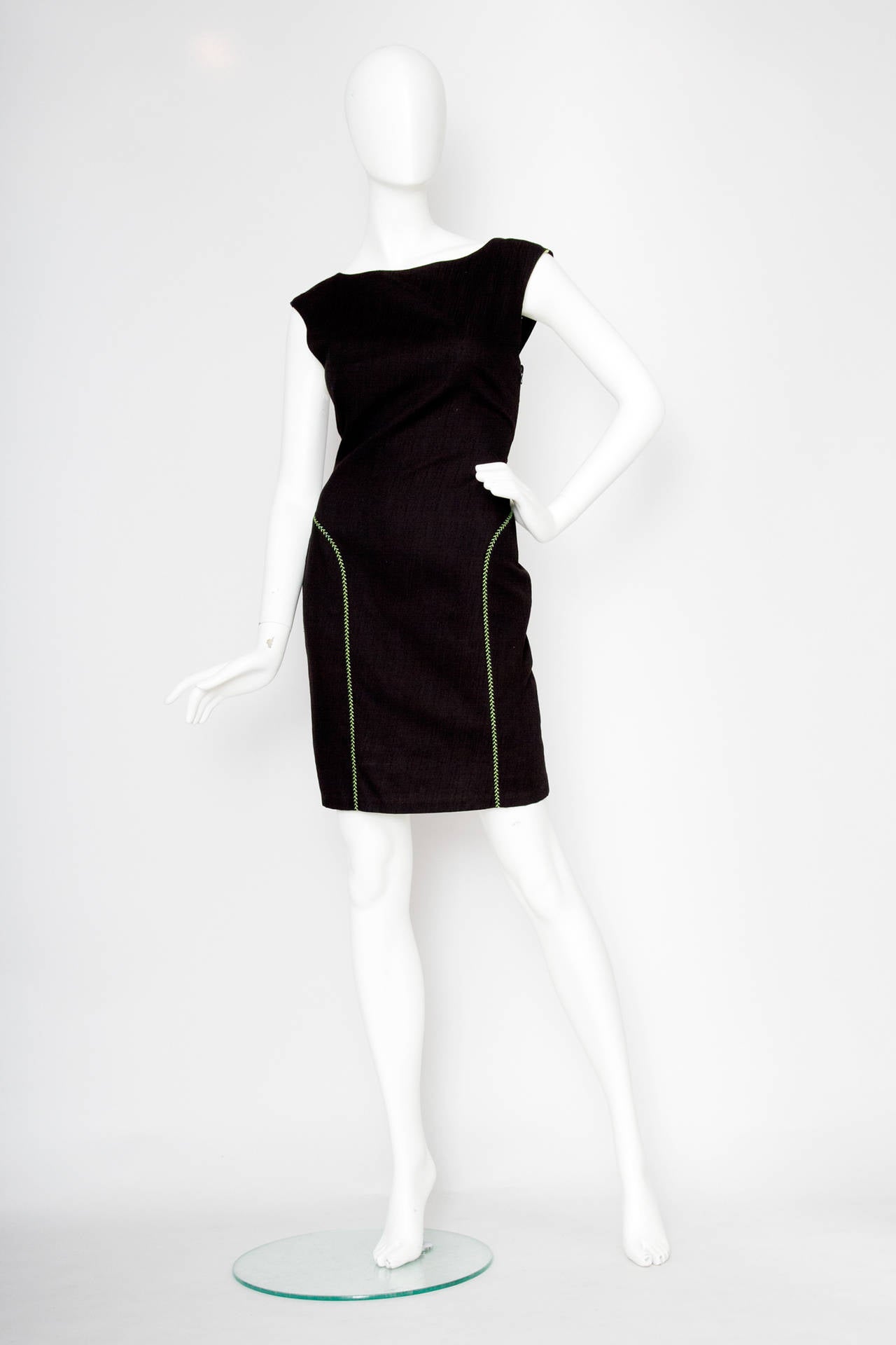 A lovely 1980s Gianni Versace Couture black cotton cocktail dress with a bright green topstitching detail throughout. The dress has a high scoop neckline and a low back. The straps have a wrap detail attached to the back and transcends as cap