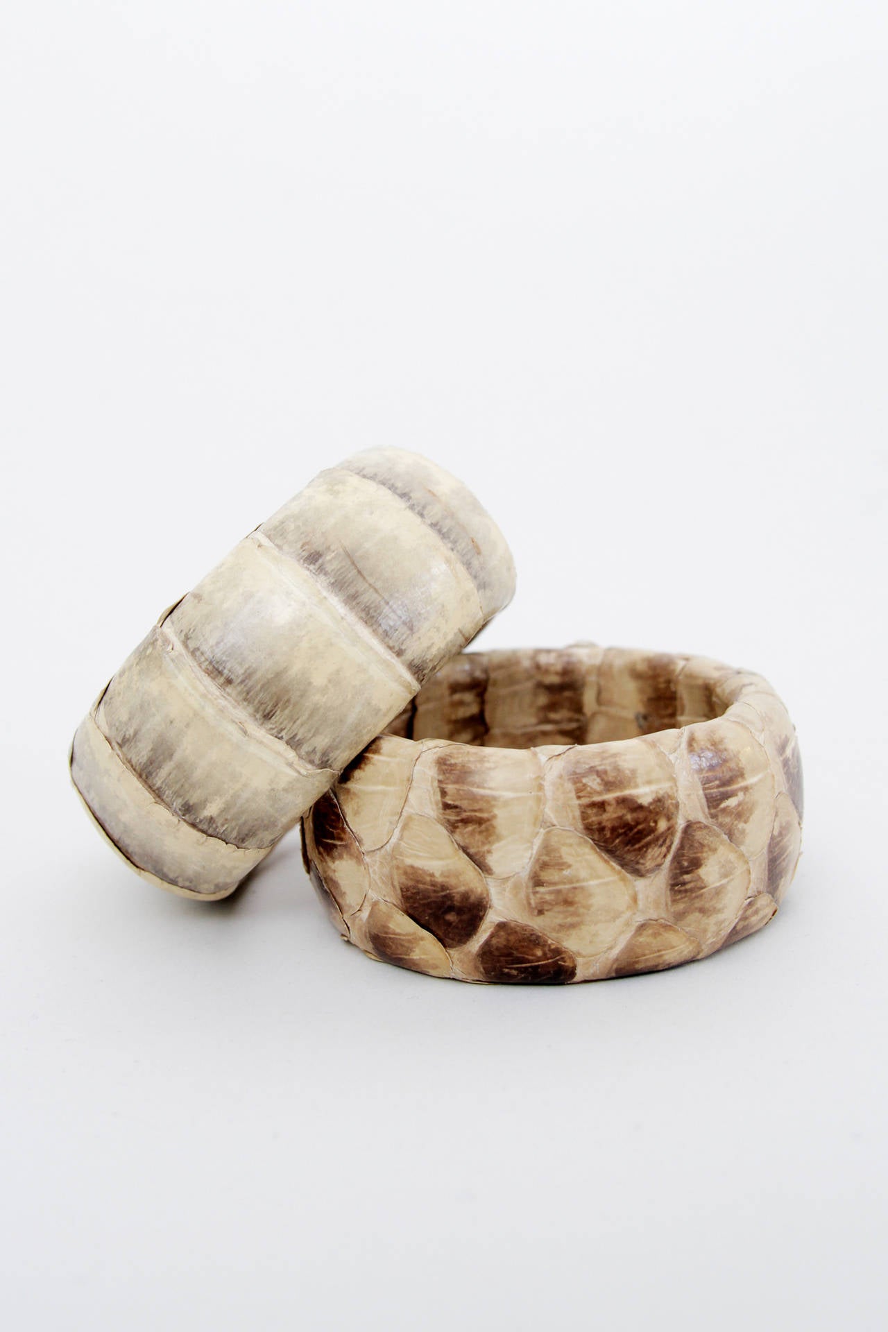 A pair of circa 1970s python skin bangles. The bangles has two different patterns in various hues of brown.