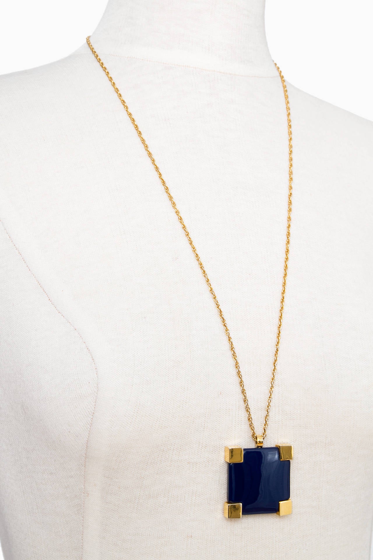 A stunning Givenchy dark blue resin pendant with gold plated square edges. The pendant is suspended to a long and delicate gold chain with 