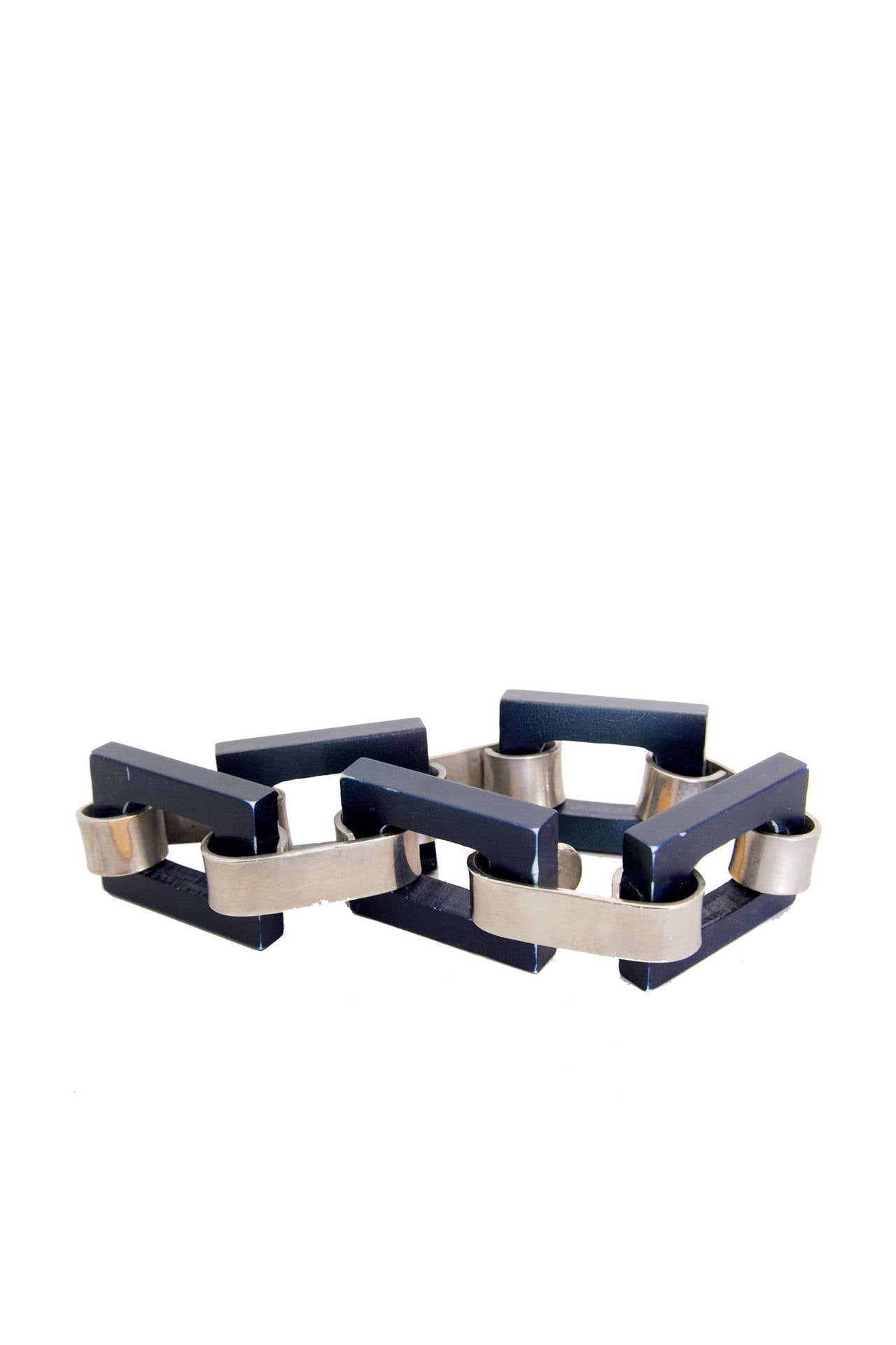 A rare and early 1970s Yves Saint Laurent link bracelet consisting of five navy squared bone and silver coloured metal pieces. 

The bracelet is stamped: YSL