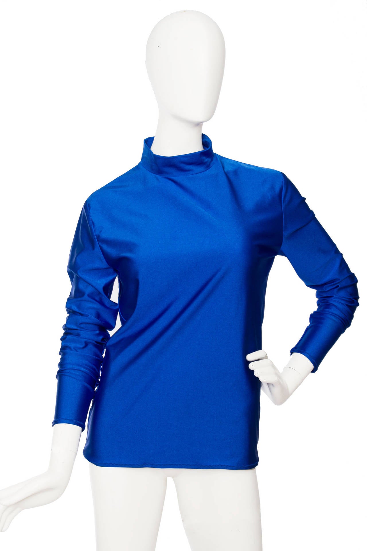 A 1990s Jean Paul Gaultier electric blue blouse with turtleneck and long sleeves. The blouse in made in a stretchy polyamide fabric giving it  a super shiny effect. 

The size of the blouse corresponds to that of a modern size Medium.