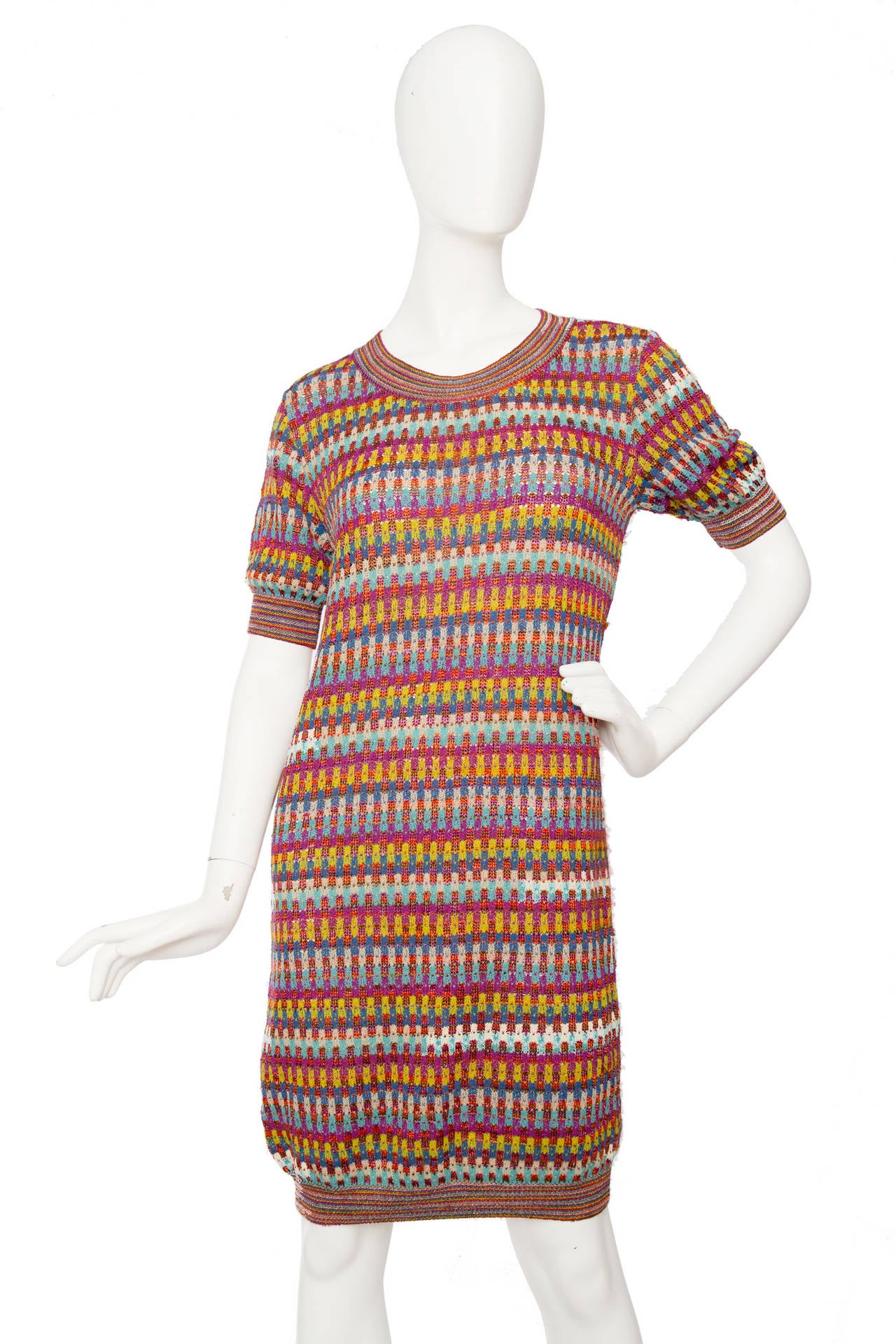 A lovely 1980s Missoni knitted dress in characteristic bold colours that vary between bright yellow, pink, and green and blue hues. The dress has a round neckline, short sleeves and a fitted hemline.

The size of the dress corresponds to a modern