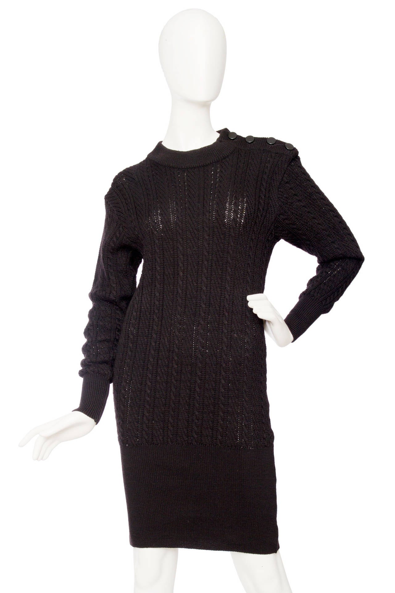 A 1980s black fitted Yves Saint Laurent Rive Gauche knitted wool dress with long tapered sleeves and a round neckline. Around the lower part of the dress a fitted panel that gently frames the body. The dress has characteristic shoulders with