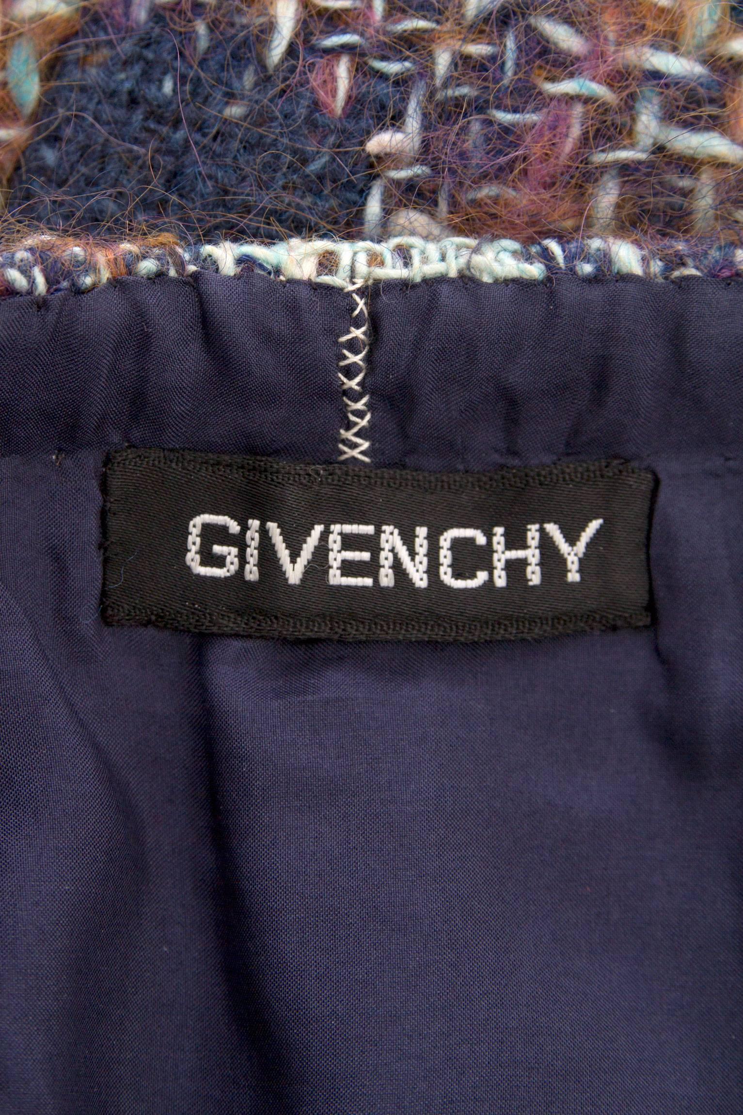 A 1970s Givenchy haute couture boucle a-line skirt held in complementing hues of blue and purple. The skirt has a conservative length cutting just below the knee but has two splits providing a feminine edge. A side zipper adds a finishing touch in