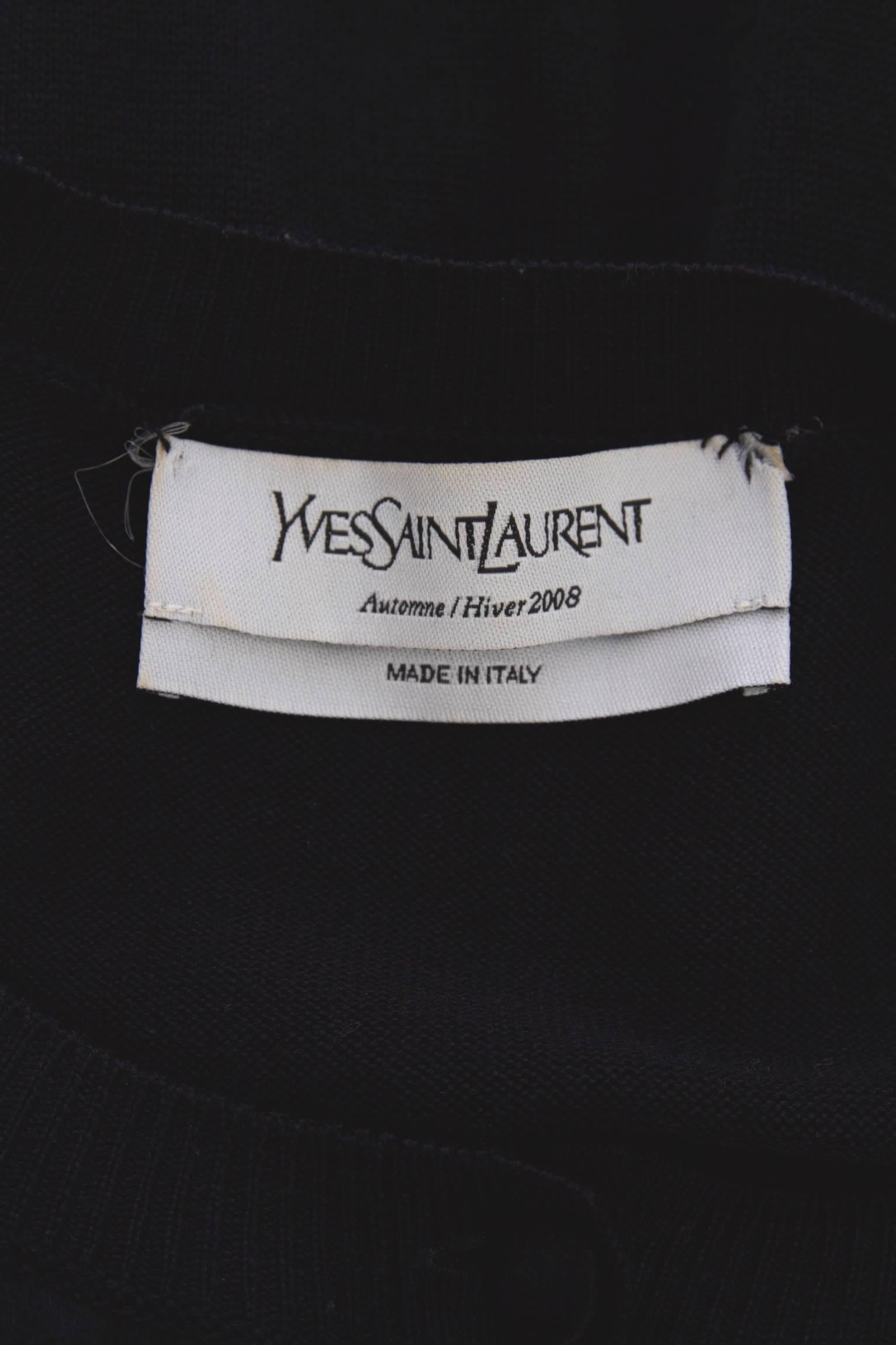 An Yves Saint Laurent black wool and silk satin dress from the Automne/Hiver 2008 collection. The dress consists of a knitted wool ballon skirt with a an elasticated hemline and side pockets. Around the waistline a tight wide elasticated band