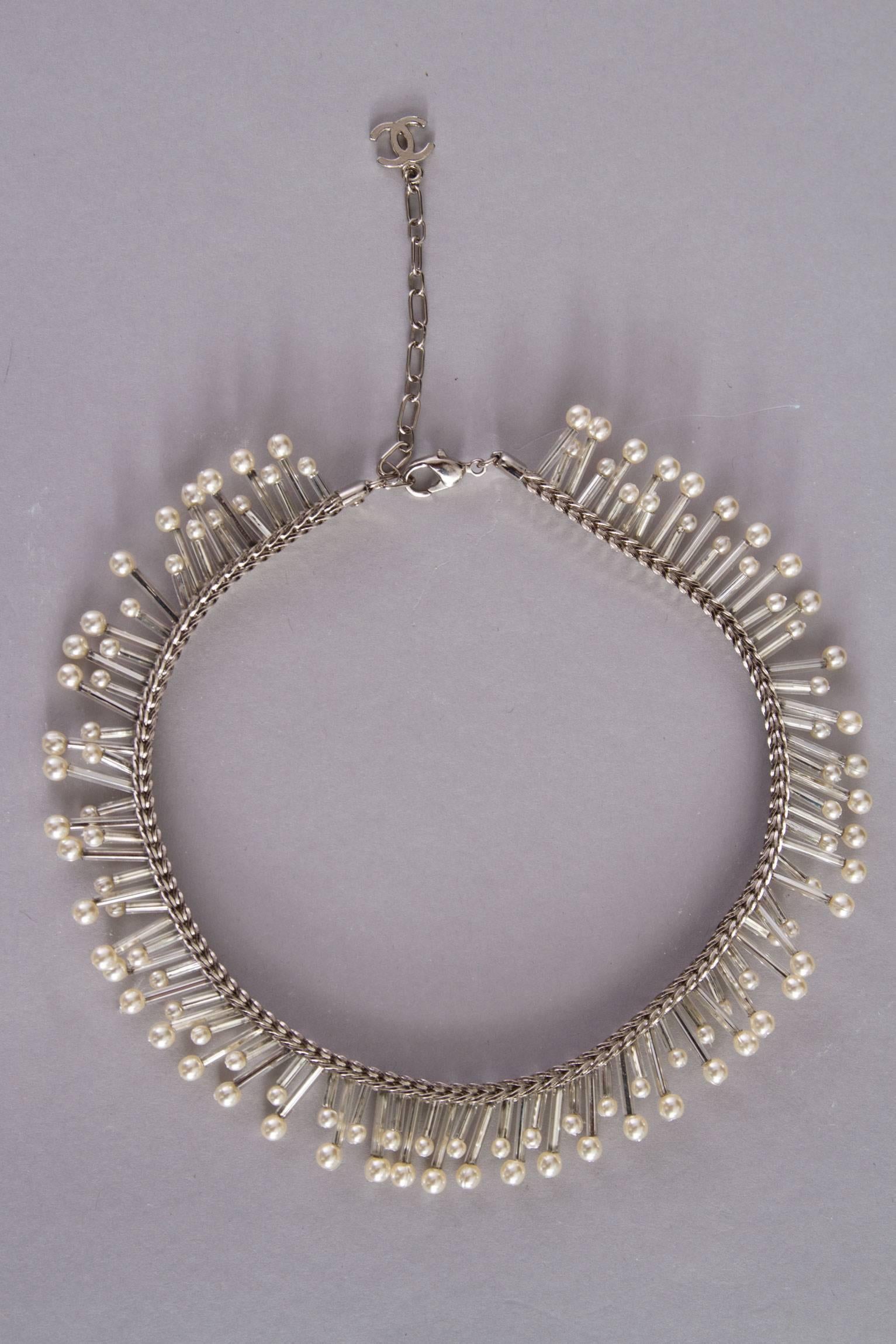 A gorgeous ca. 1990s silver Chanel beaded mother-of-pearl choker necklace. The necklace consists of a braided silver chain which is decorated with long cylinder shaped beads in varying lengths. At the end of each string a small pearl is attached. At