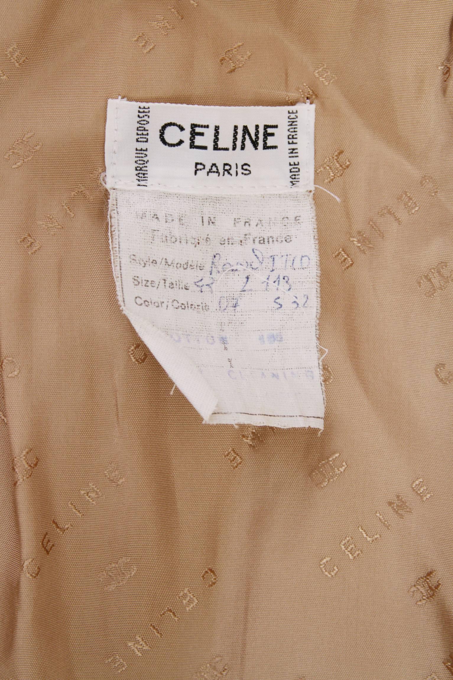 A gorgeous 1970s beige double-breasted Céline cotton trench coat with matching round gold buttons with the Céline logo imprint. A delicate white stitching detail around the hemline, side pockets and waits-belt adds a a final elegant touch to the