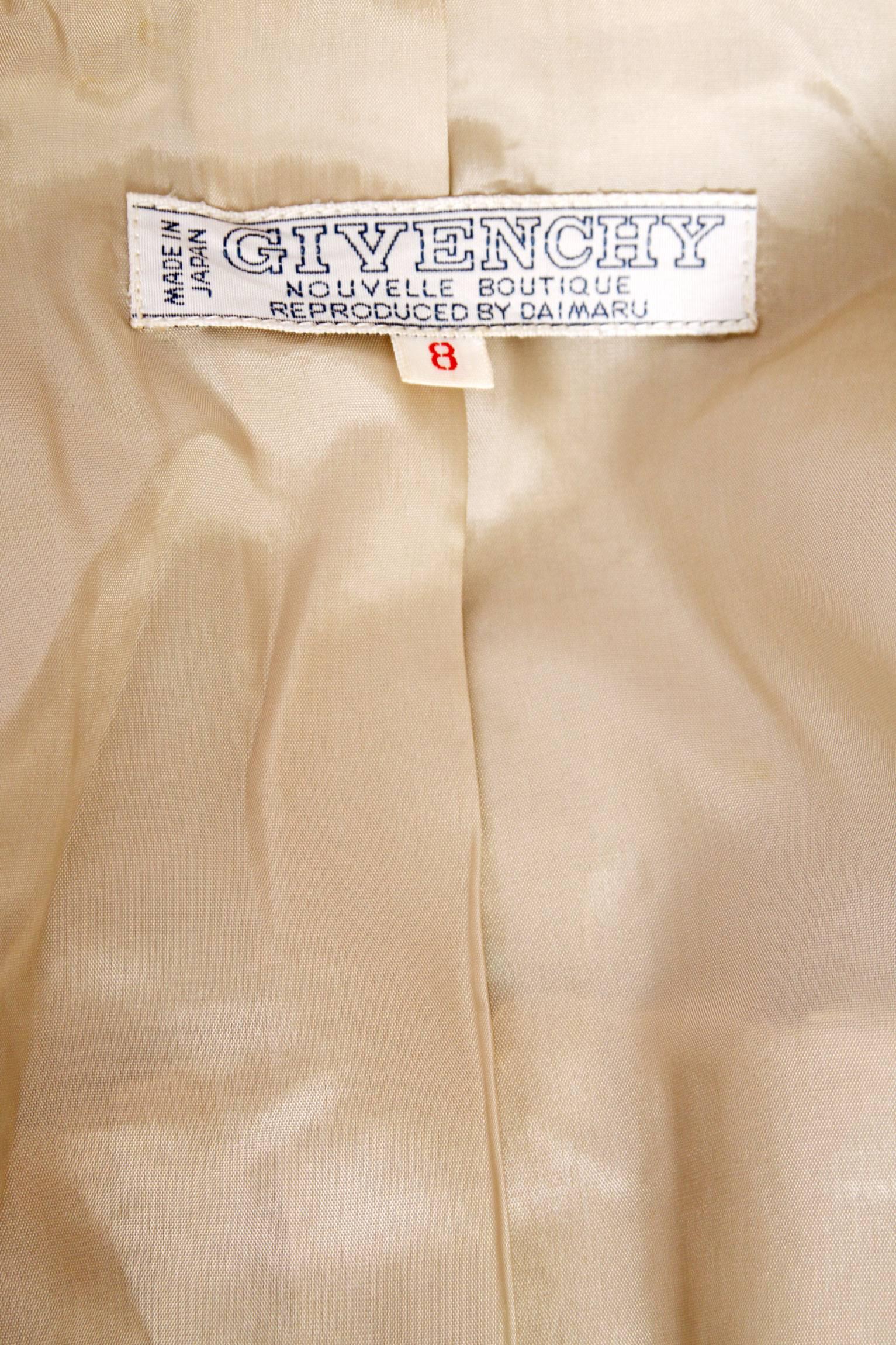 A fitted 1960s Givenchy beige wool coat with a double breasted front button closure and a complementing light brown checkered print. A split back provides added room around the lower part of the body, whilst a fitted waistline and tapered sleeves