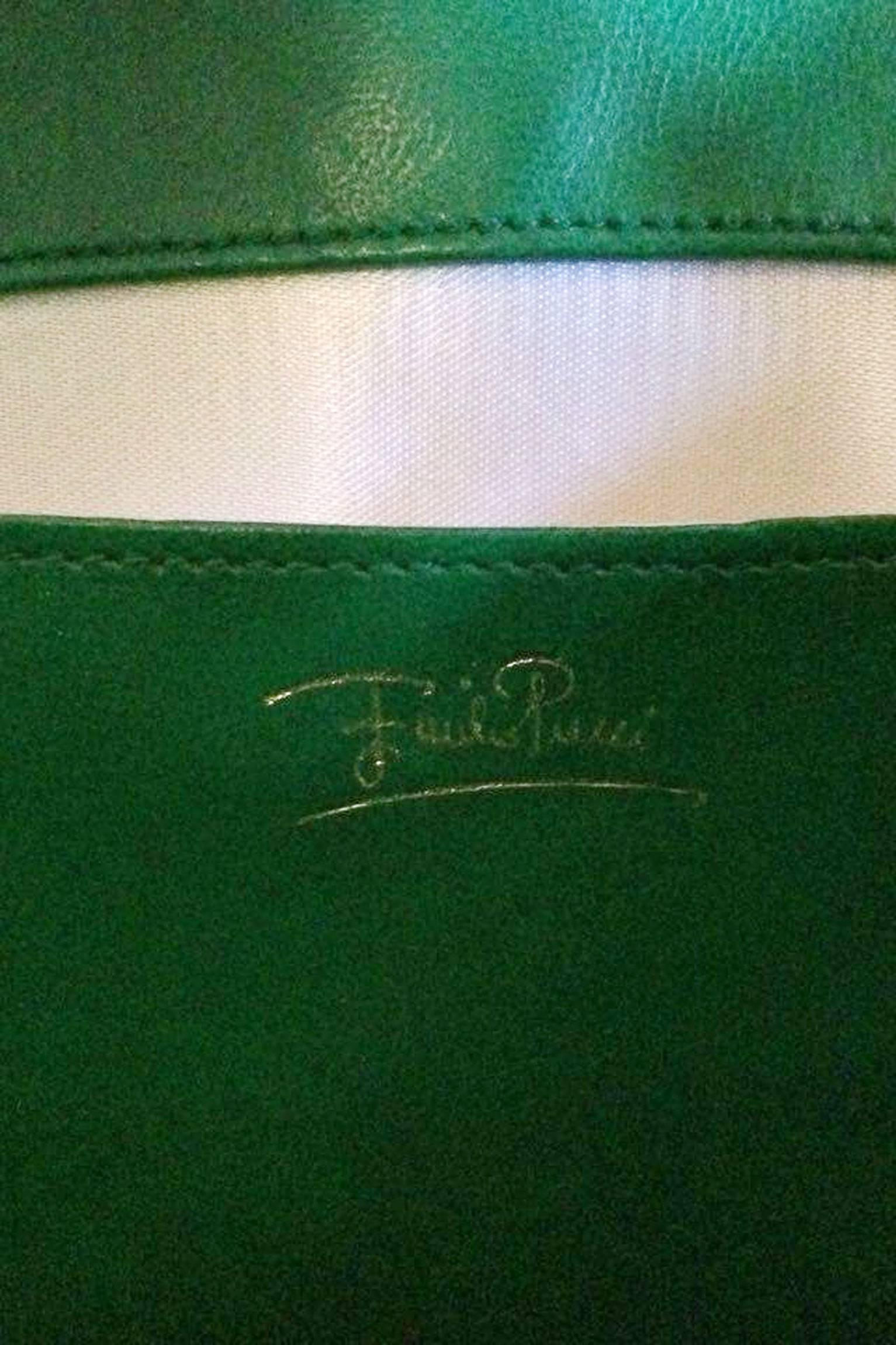 A gorgeous 1960s Emilio Pucci box shoulder bag with a green adjustable leather strap and gold hardware. The bag is printed with the iconic Pucci print, which is held in a green color palate with blue and purple accents. The bag has one large