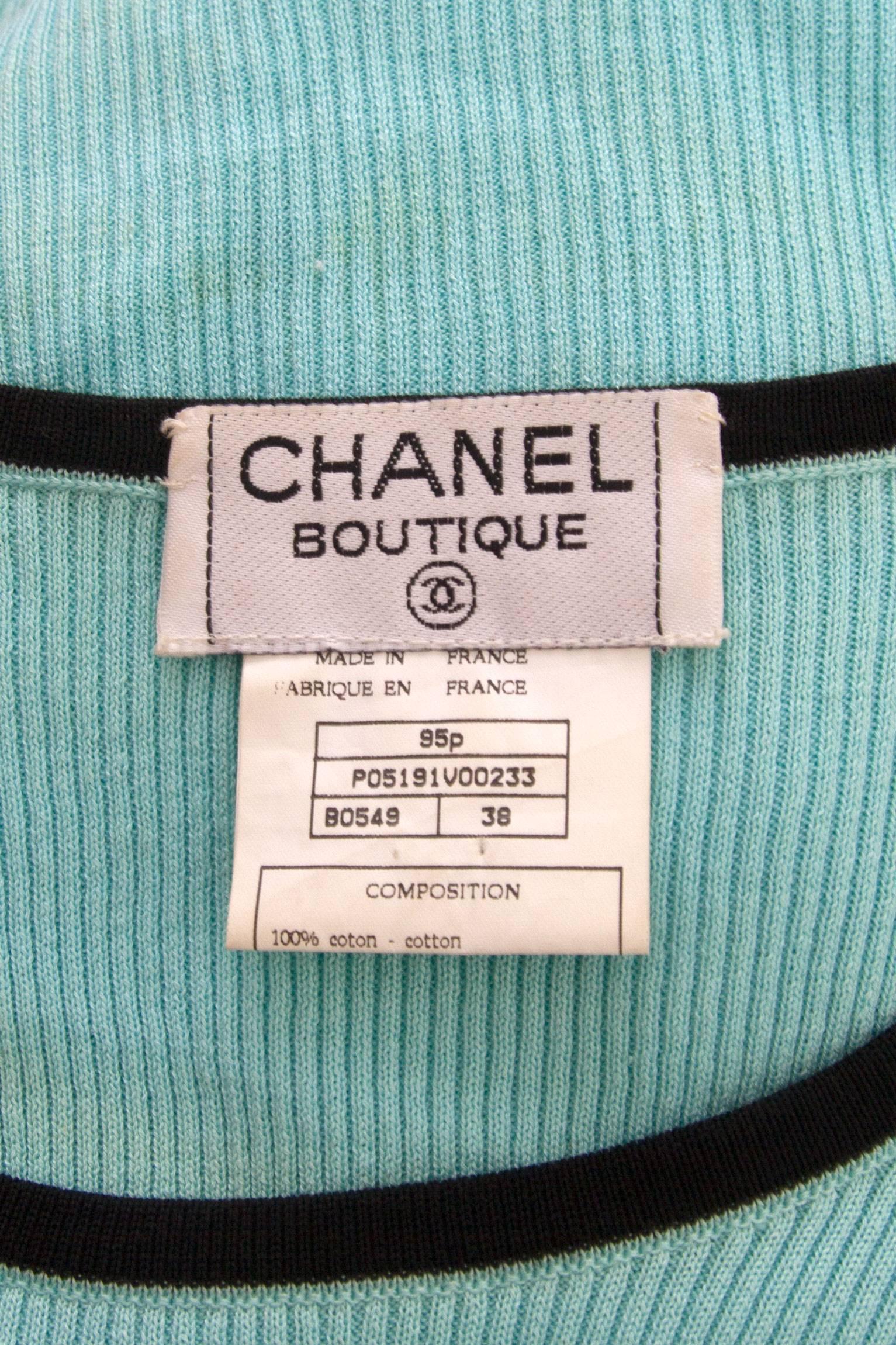 A cute 1990s turquoise Chanel cropped cotton top with cap sleeves and contrasting black piping along the hem, neckline and sleeves. In the centre front, the top has a small black Chanel logo embroidered. 

The size of the top corresponds to a